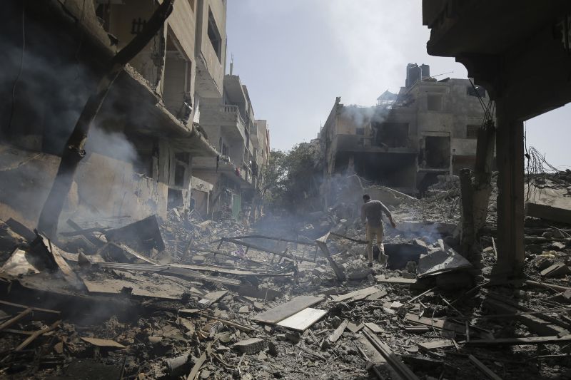 Palestinians look at the aftermath of the Israeli bombing in Nuseirat refugee camp, Gaza Strip, Saturday.