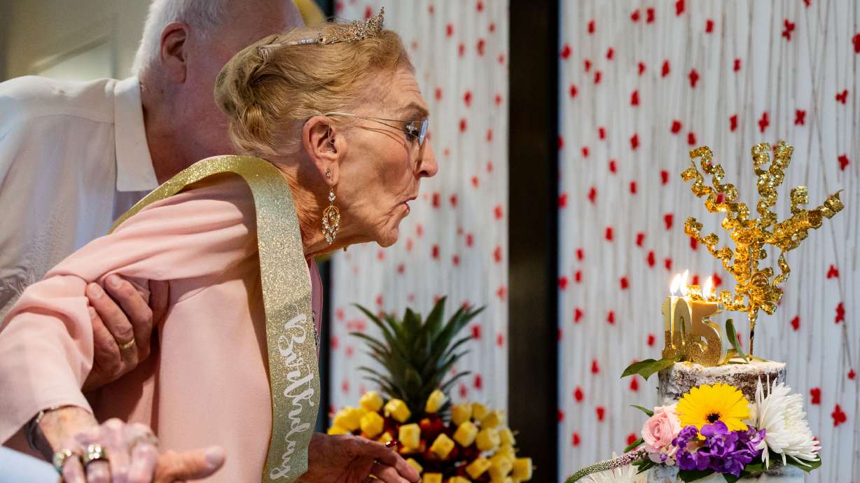 Georgia Presnell blows out the candles as she celebrates her 105th birthday with family and friends at Treeo, a senior living center, in Orem on Friday.