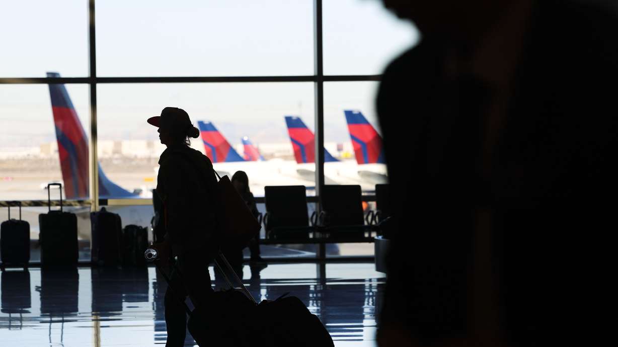 People walk through the Salt Lake City International Airport on Nov. 21, 2023. A 28-year-old with "no legitimate business at the airport" was arrested Sunday after police say he attacked two young men at the arrivals terminal.