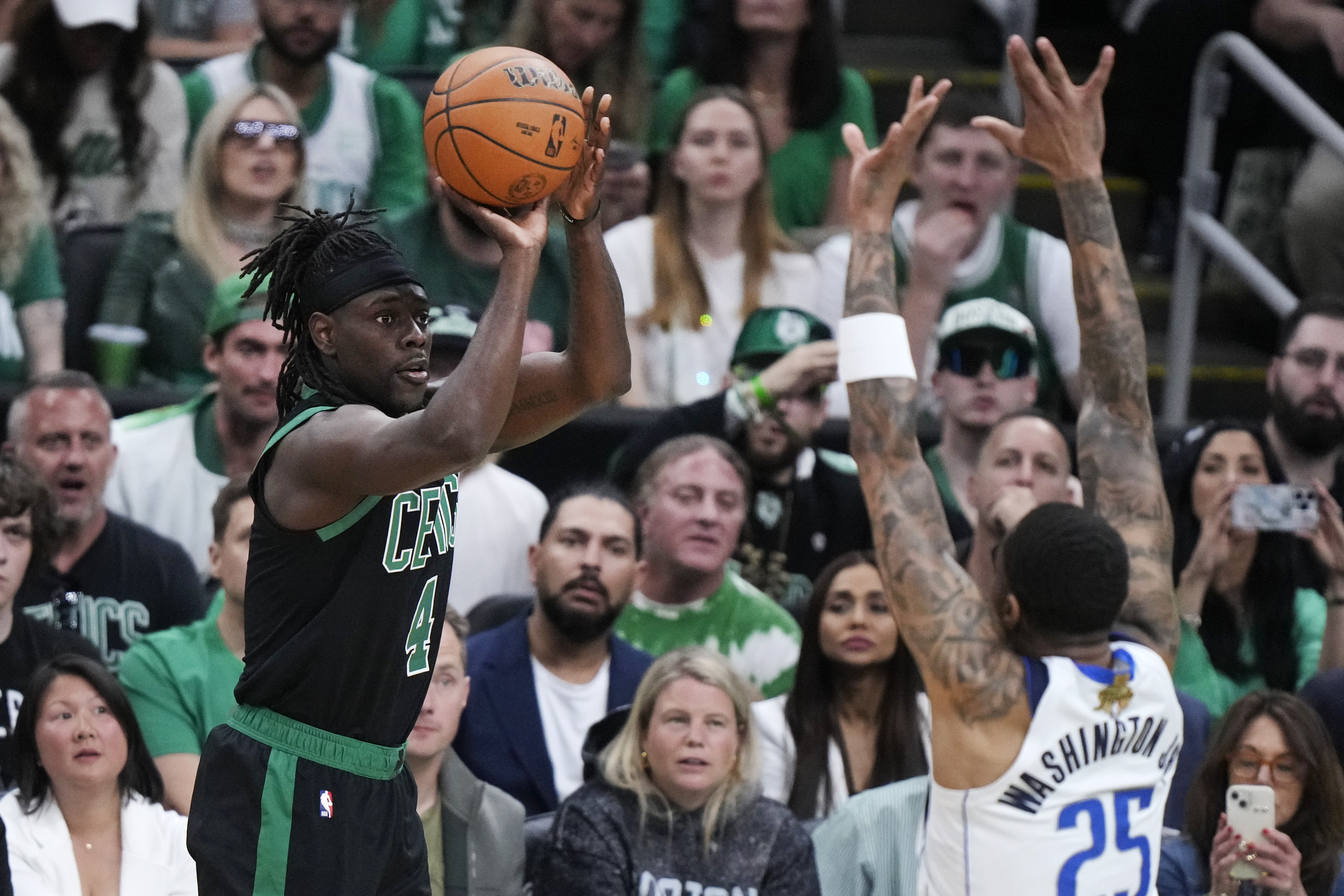 Boston Celtics guard Jrue Holiday takes a shot over Dallas Mavericks forward P.J. Washington (25) during the first half of Game 2 of the NBA Finals basketball series, Sunday, June 9, 2024, in Boston.