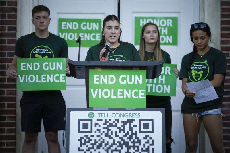 Emma Ehrens, center, a survivor of the 2012 Sandy Hook Elementary School shooting speaks as she stands with other survivors during a rally against gun violence on June 7 in Newtown, Conn.