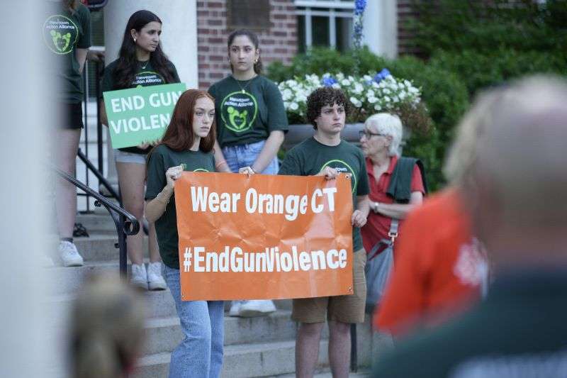 Members of Junior Newtown Action Allience hold signs during a rally against gun violence on June 7 in Newtown, Conn.
