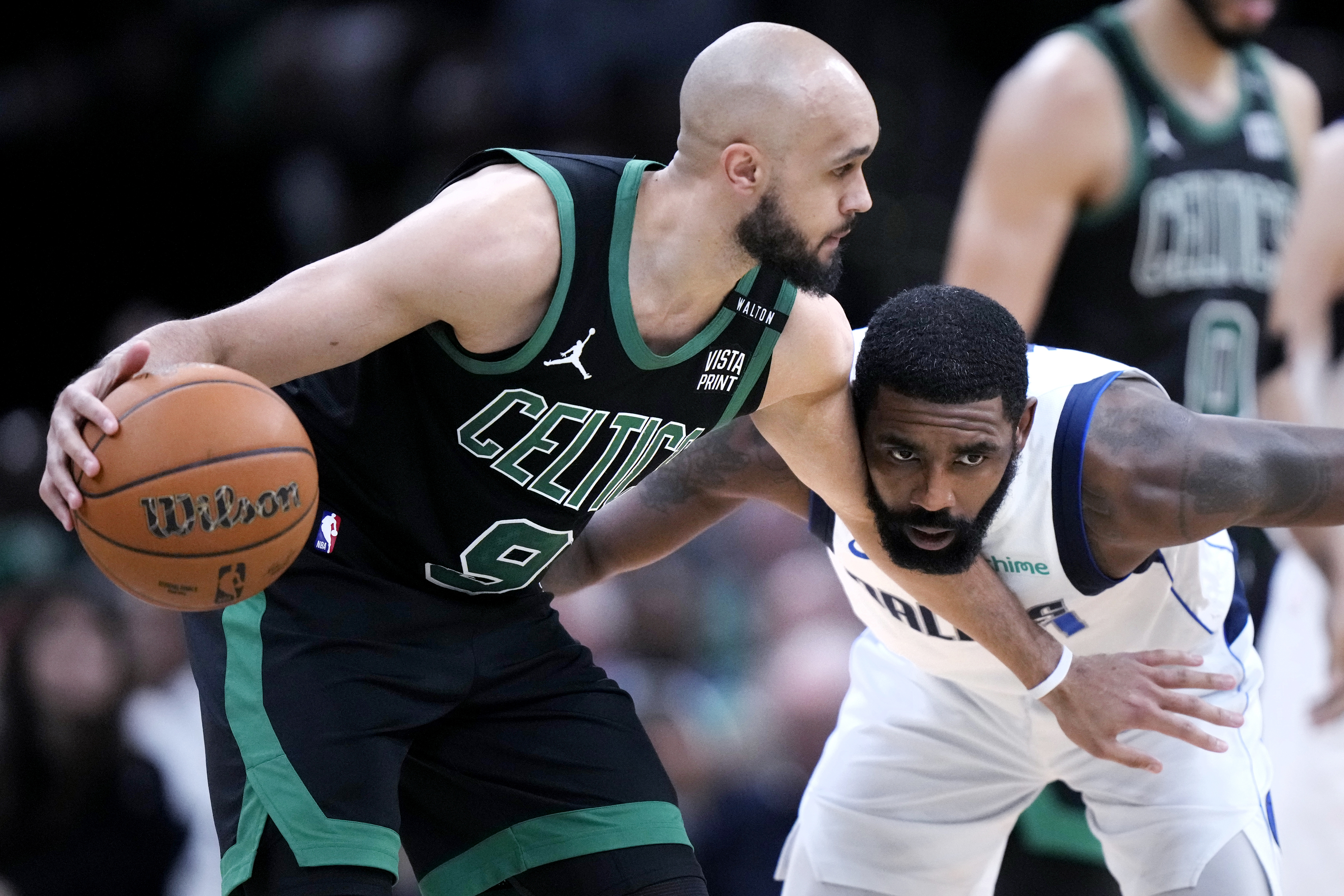 Boston Celtics guard Derrick White (9) holds back Dallas Mavericks guard Kyrie Irving while looking to pass during the second half of Game 2 of the NBA Finals basketball series, Sunday, June 9, 2024, in Boston. 