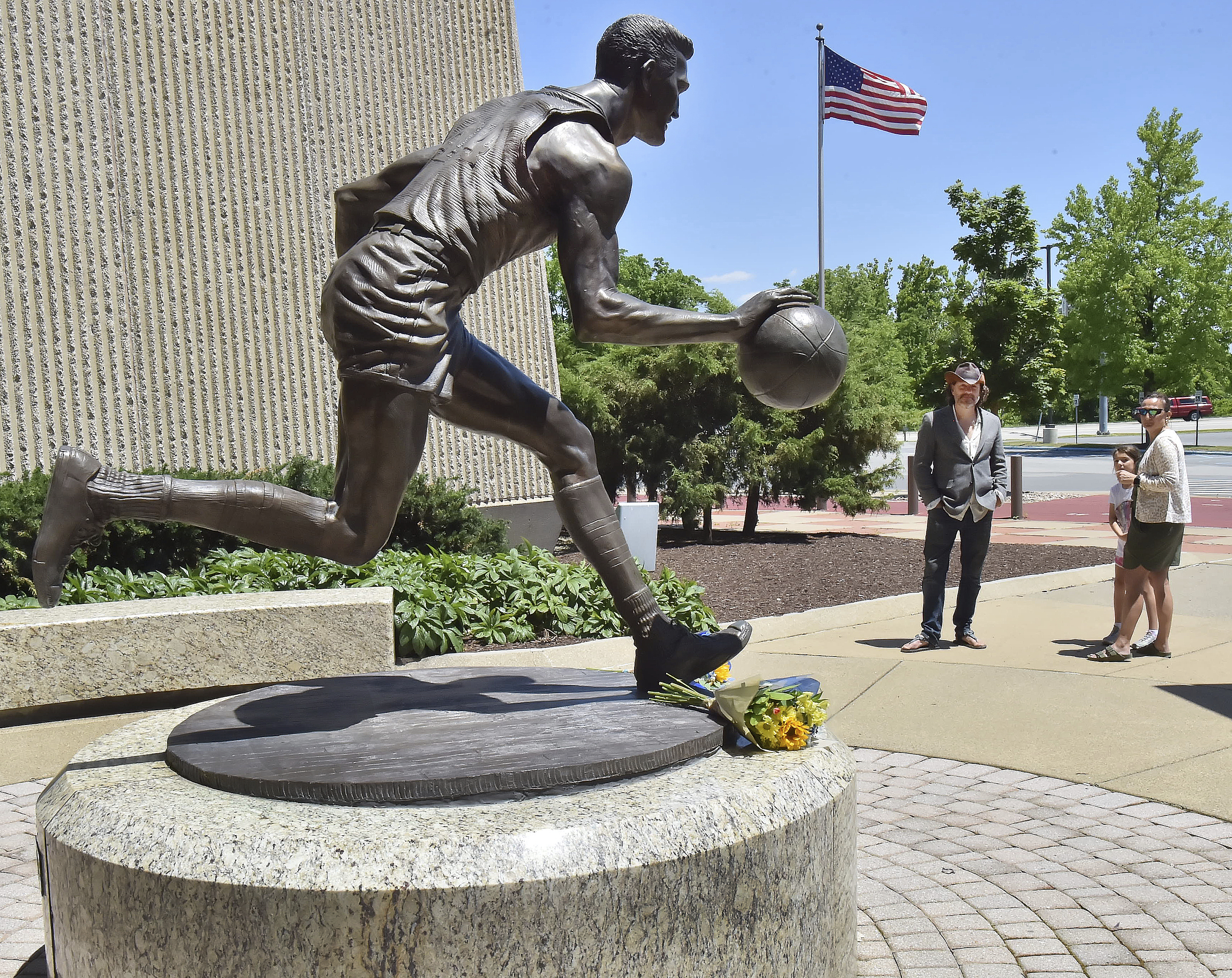 Visitors pause at the statue of West Virginia's Jerry West, Wednesday, June 12, 2024, outside the WVU Coliseum in Morgantown, W.Va. West, who was selected to the Basketball Hall of Fame three times in a storied career as a player and executive, and whose silhouette is considered to be the basis of the NBA logo, died Wednesday morning. He was 86. 