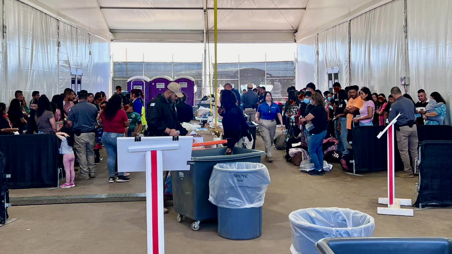Recent arrivals to the United States at a border processing facility near Tucson, Arizona, sometime in May. The faces of minors have been covered.