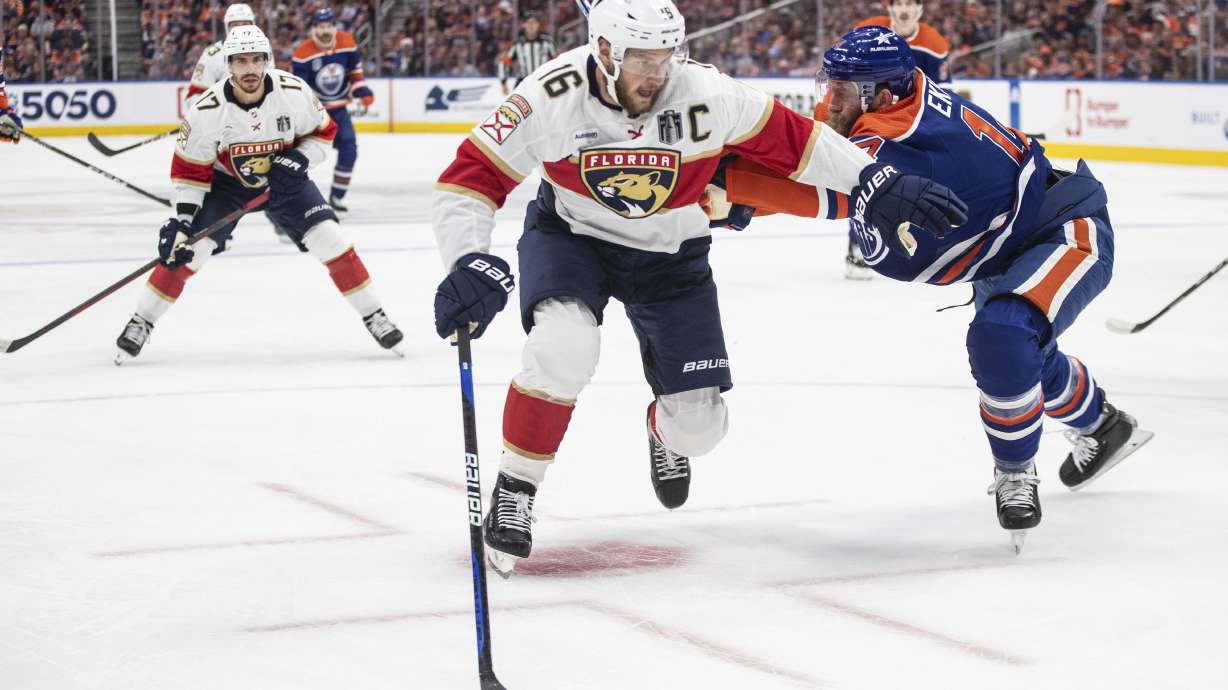 Florida Panthers' Aleksander Barkov (16) and Edmonton Oilers' Mattias Ekholm (14) vie for the puck during the first period of Game 3 of the NHL hockey Stanley Cup Finals, Thursday, June 13, 2024, in Edmonton, Alberta.