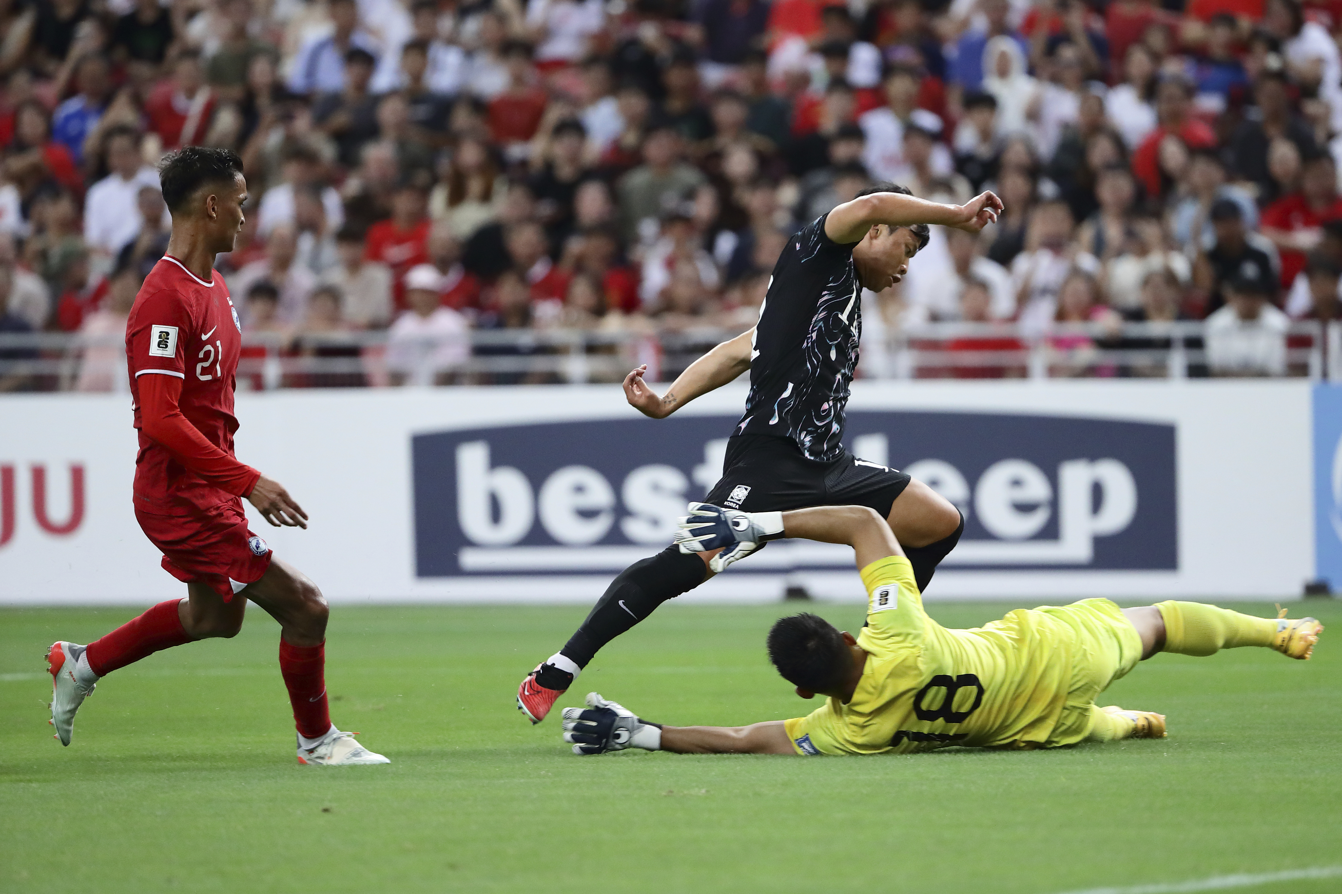 Hwang Hee Chan of South Korea tries to dribble past Hassan Sunny of Singapore during 2026 FIFA World Cup Asian 2nd Qualifier soccer match between Singapore and South Korea at the National Stadium in Singapore, on Thursday, June 6, 2024. Chinese soccer fans have poured their love — and money — into Hassan Sunny’s food stall after his performance in a game this week indirectly helped China advance to the third qualifying round for the World Cup in 2026. 