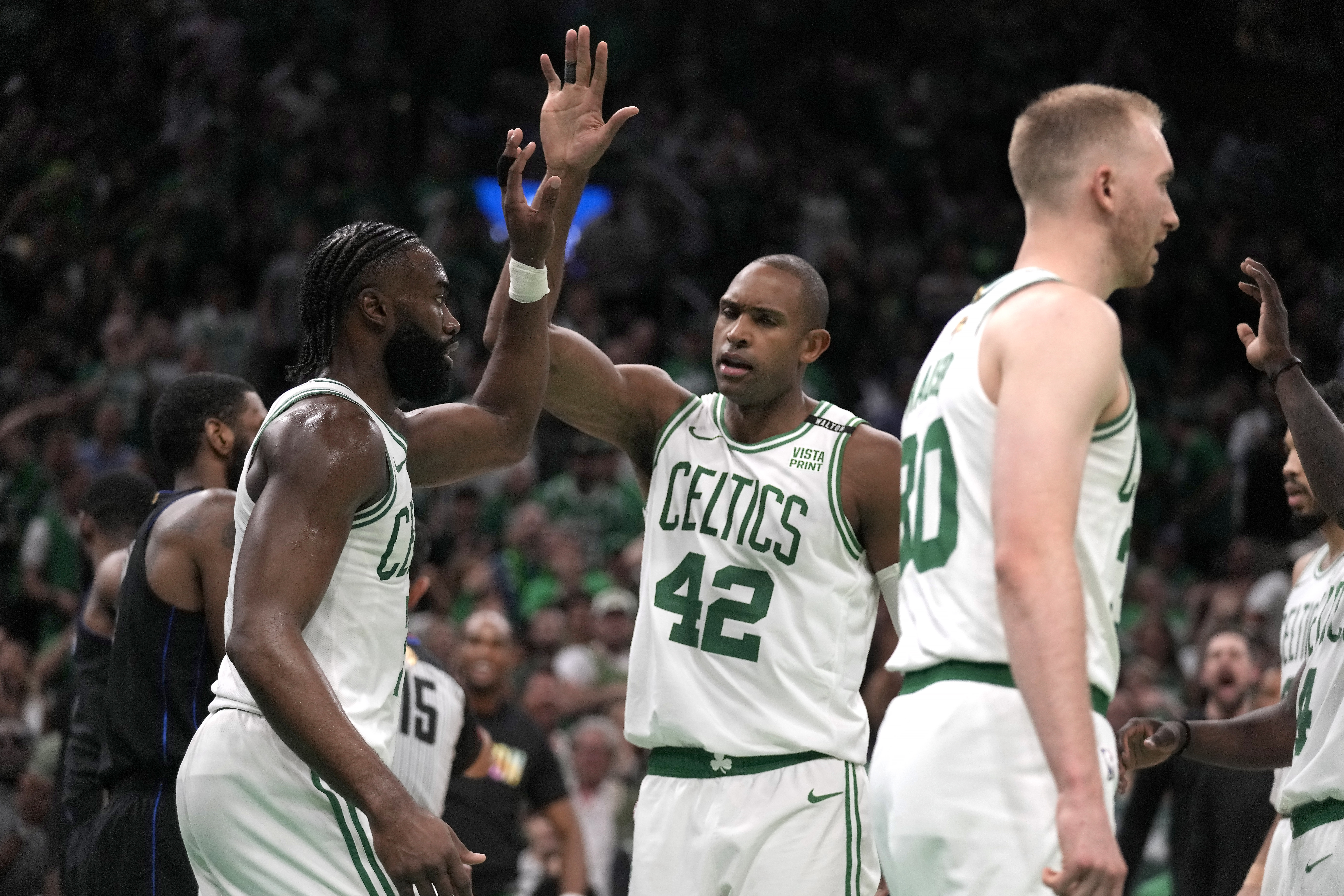 Boston Celtics guard Jaylen Brown, left, celebrates with center Al Horford, center, as the Celtics lead the Dallas Mavericks during the second half of Game 1 of the NBA Basketball Finals against the Dallas Mavericks, Thursday, June 6, 2024, in Boston.