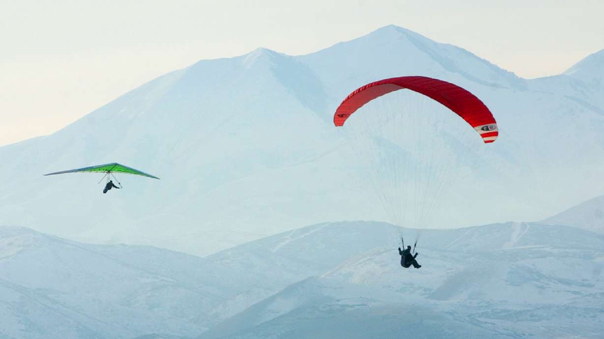 A hang glider and paraglider soar peacefully over Draper Dec. 23, 2002. One person was injured while hang gliding in Draper on Friday.