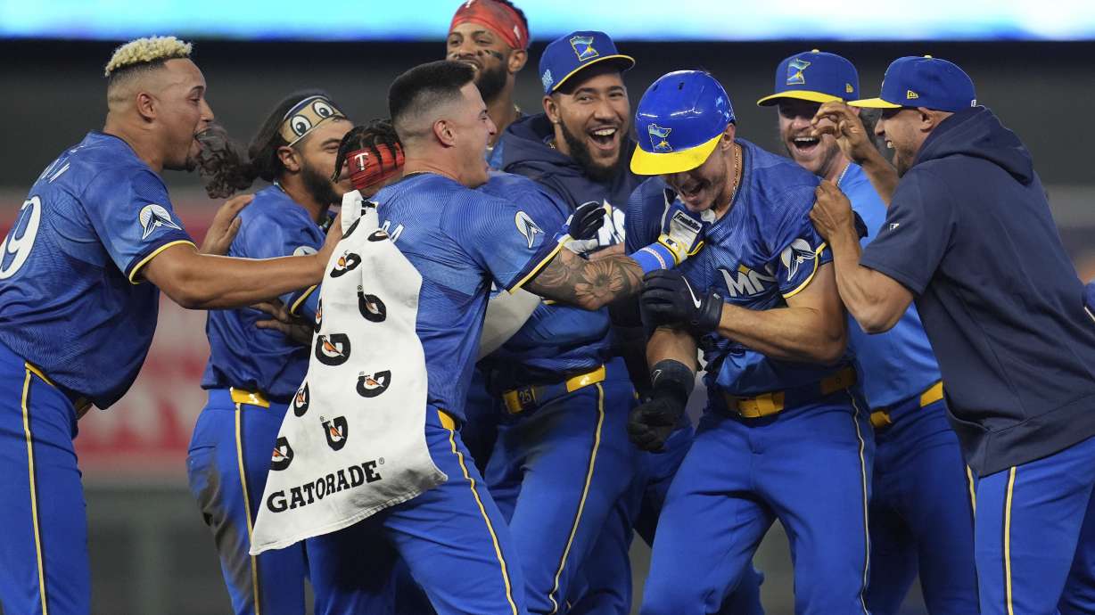 Minnesota Twins' Max Kepler, third from right, celebrates with teammates after driving in the winning run against the Oakland Athletics during the 10th inning of a baseball game Friday, June 14, 2024, in Minneapolis.