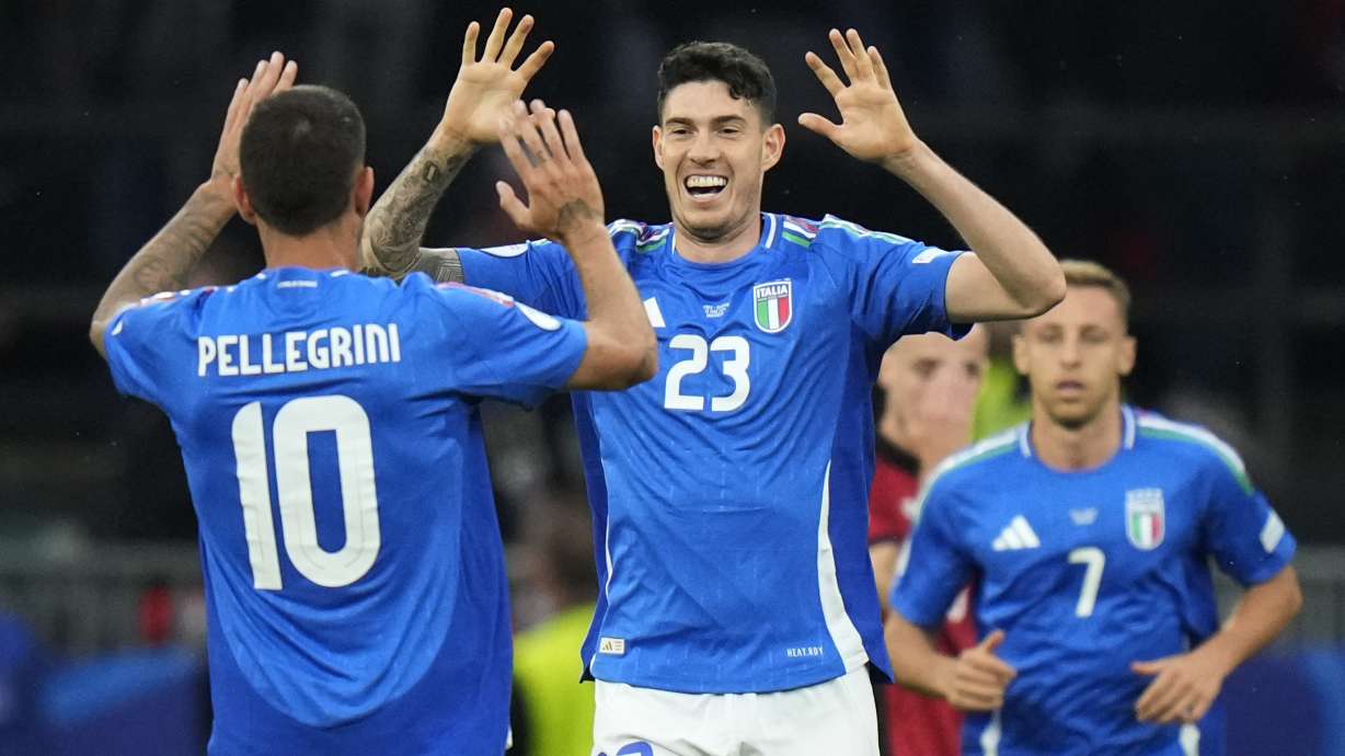 Italy's Alessandro Bastoni, center, celebrates with his teammate Lorenzo Pellegrini after scoring his side's opening goal during a Group B match between Italy and Albania at the Euro 2024 soccer tournament in Dortmund, Germany, Saturday, June 15, 2024.