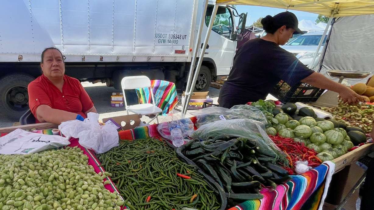 Estela Paredes, left, at her produce stand at the Redwood Swap Meet in West Valley City on Saturday.
