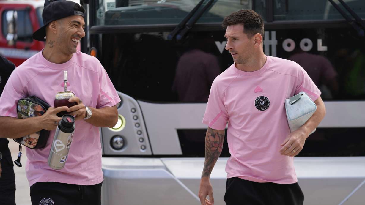 Inter Miami forwards Luis Suarez, left, and Lionel Messi talk as they arrive for the team's MLS soccer match against St. Louis City, Saturday, June 1, 2024, in Fort Lauderdale, Fla.