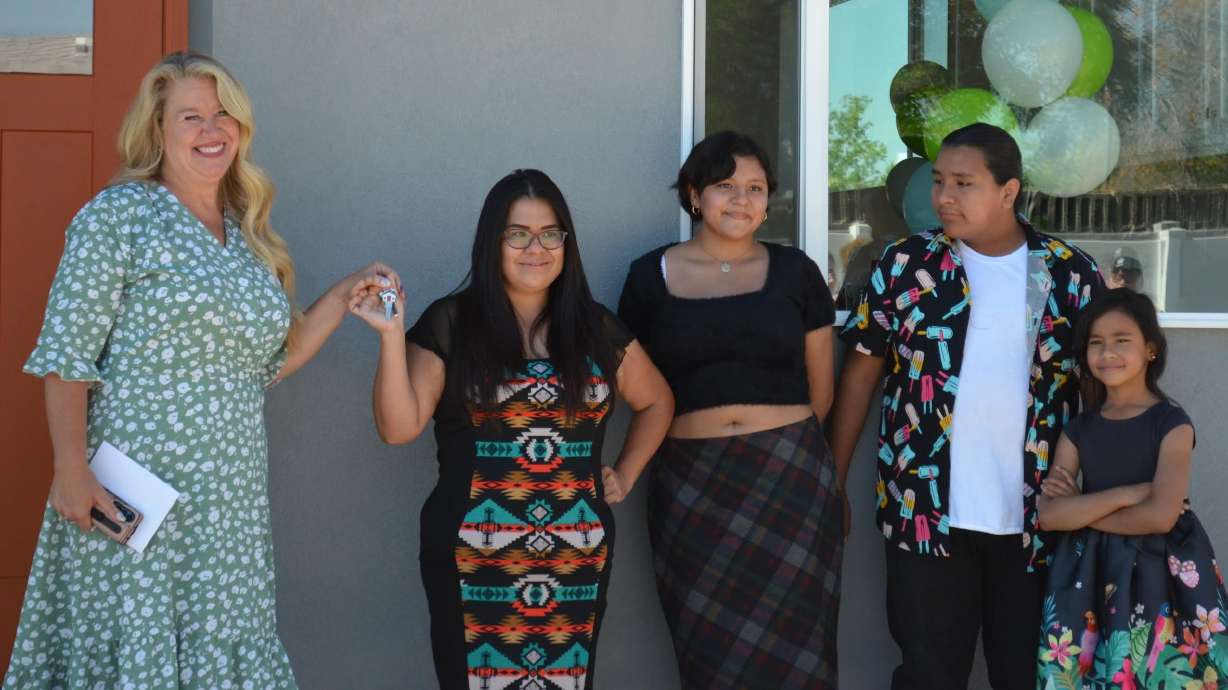 Salt Lake Valley Habitat for Humanity on Tuesday presented three families the keys to their new homes in Kearns.