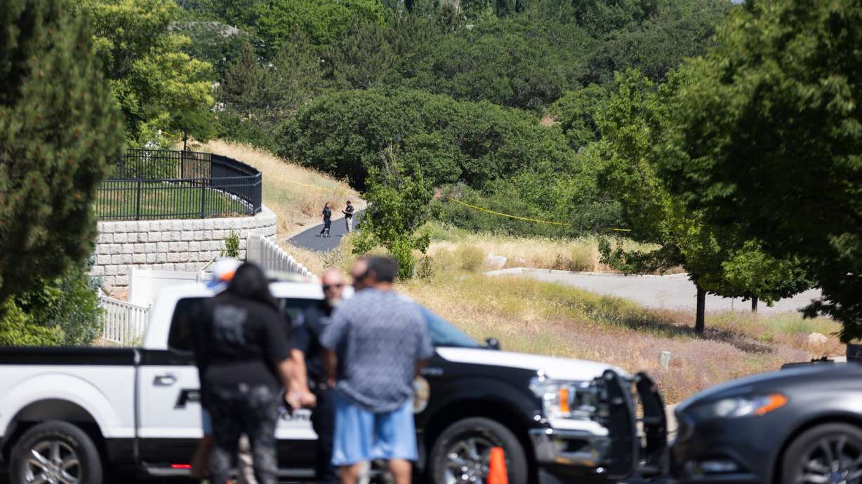 Law enforcement and investigators walk the scene where a man was shot near Glenmoor Field, along Skye Drive (9585 South) about a half-mile east of Skye Park (4800 West), in South Jordan on Saturday. The man later died at a hospital.