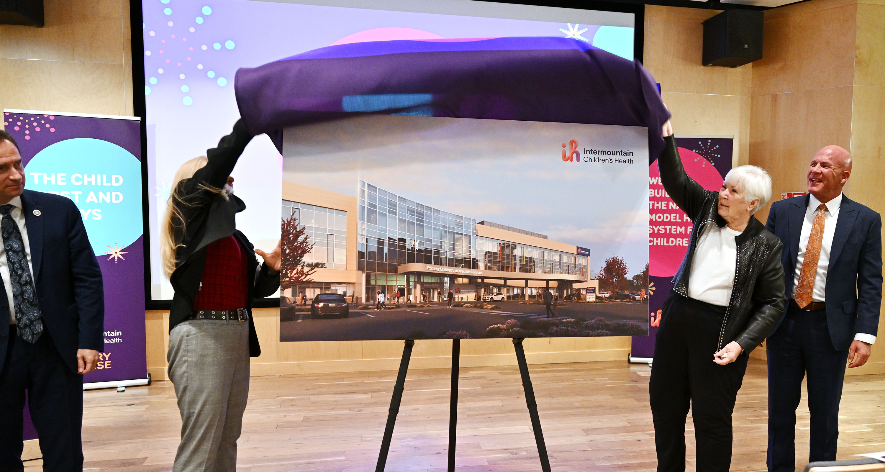 Katy Welkie, Intermountain Children’s Health CEO, and Gail Miller, Utah philanthropist, lift the covering off the rendering image as leaders unveil plans for the new first-of-its-kind $96-million pediatric behavioral health center, in Salt Lake City on Monday.