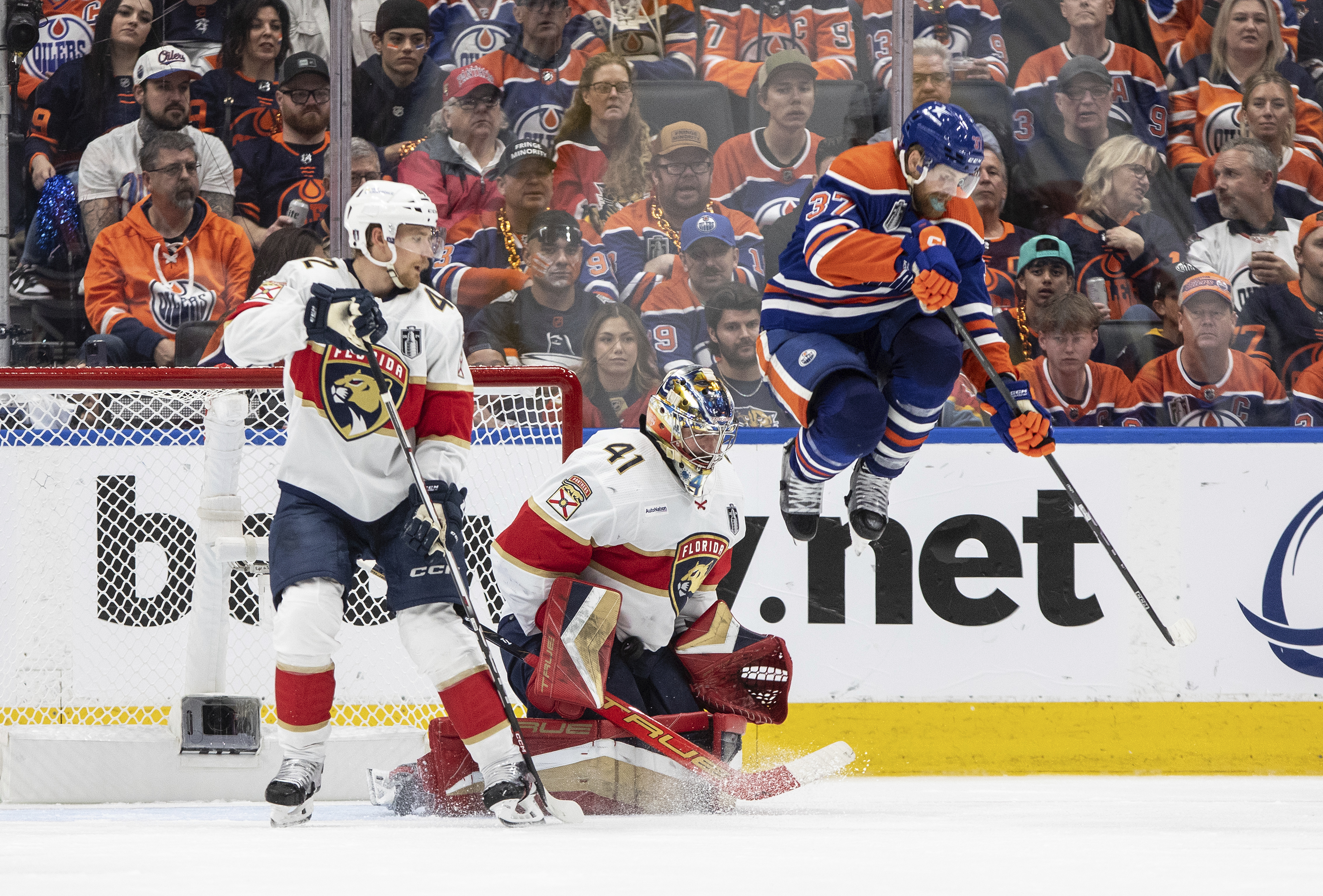 Florida Panthers goalie Anthony Stolarz (41) makes a save as Edmonton Oilers' Warren Foegele (37) leaps and Gustav Forsling (42) defends during the third period of Game 4 of the NHL hockey Stanley Cup Final, Saturday, June 15, 2024, in Edmonton, Alberta. 