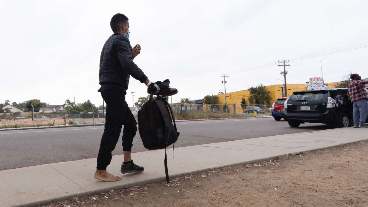 An immigrant seeking asylum looks for transportation after being processed and released, June 4 in San Diego, California.