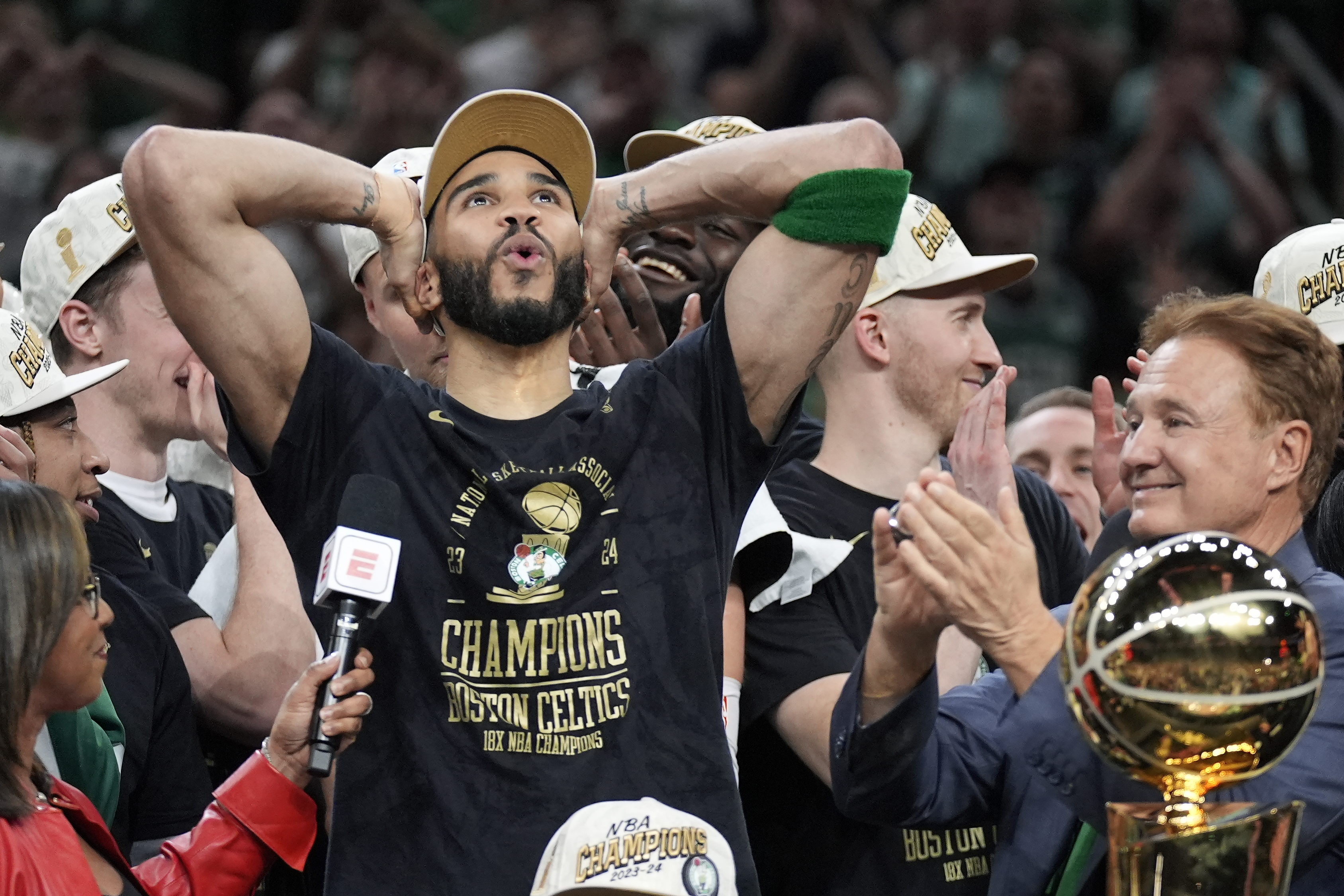 Boston Celtics forward Jayson Tatum, left, celebrates next to Celtics co-owner Stephen Pagliuca, right, near the Larry O'Brien Championship Trophy after the Celtics won the NBA championship with a Game 5 victory over the Dallas Mavericks on Monday, June 17, 2024, in Boston. 