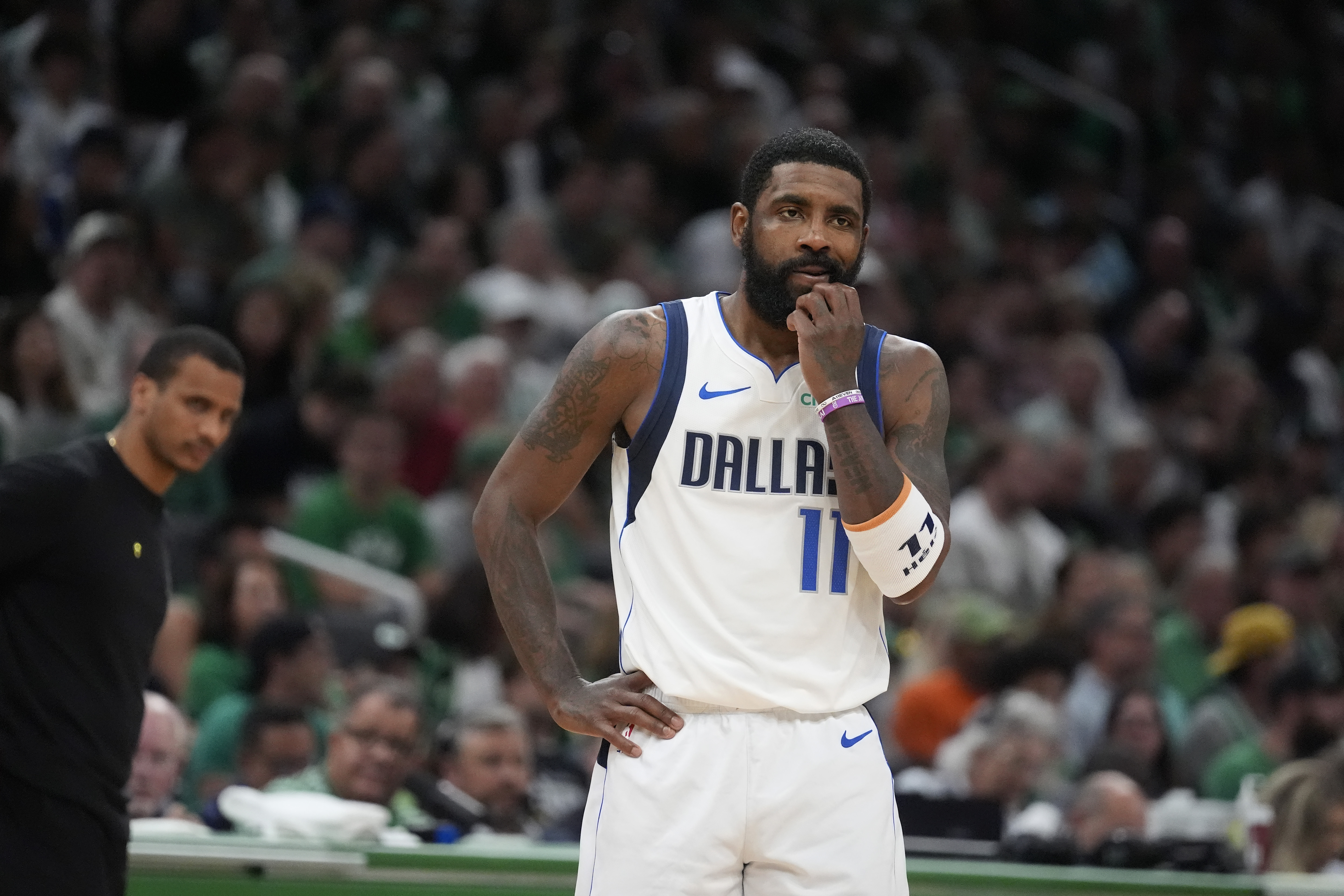 Dallas Mavericks guard Kyrie Irving pauses on the court in front of Boston Celtics head coach Joe Mazzulla, left, during the first half of Game 5 of the NBA basketball finals, Monday, June 17, 2024, in Boston.
