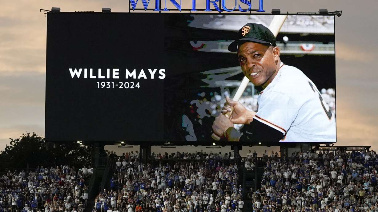 Fans stand for a moment of silence for former MLB player Willie Mays during the sixth inning of a baseball game between the San Francisco Giants and the Chicago Cubs in Chicago, Tuesday, June 18, 2024.