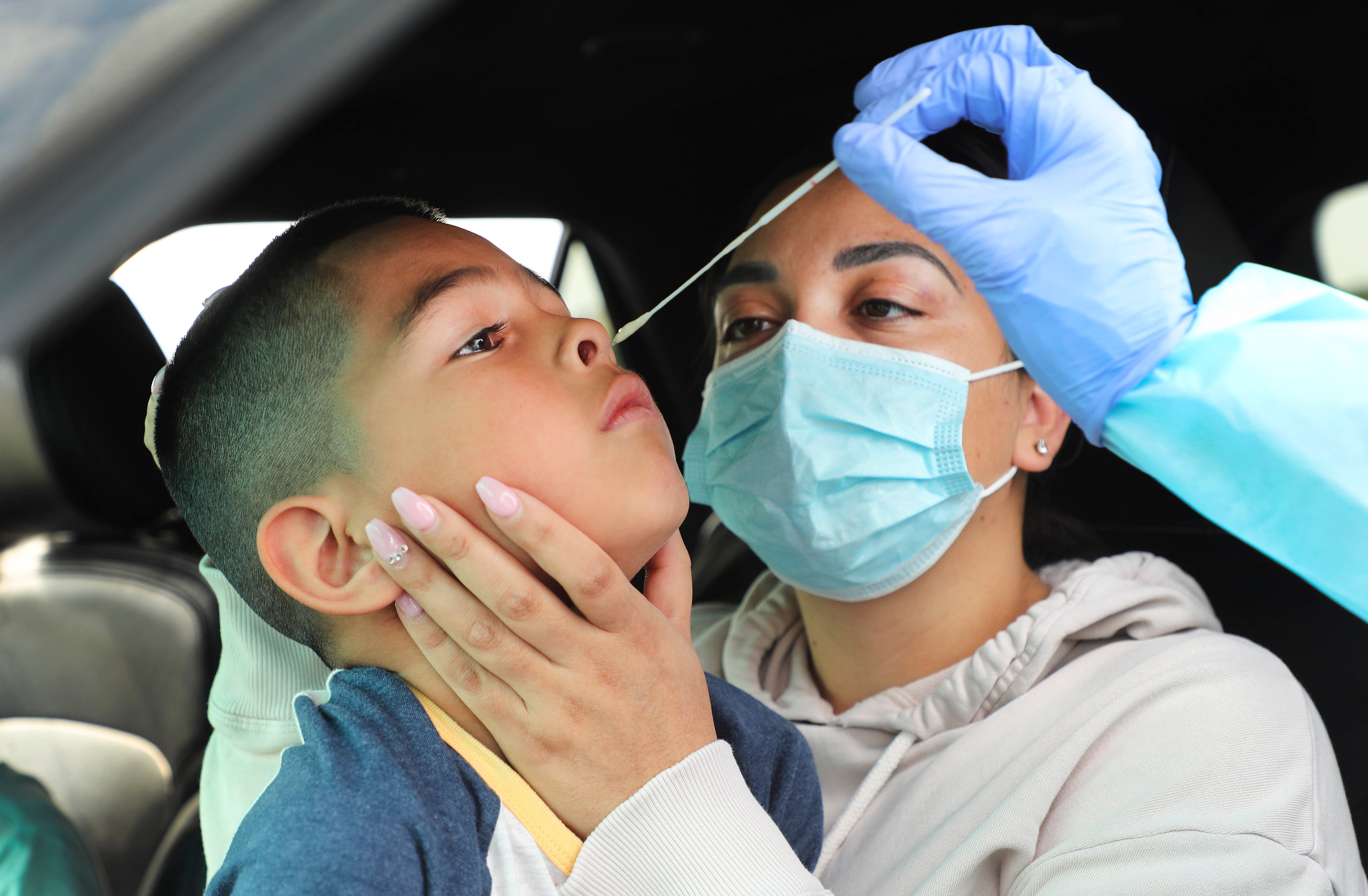 Yanet Alcaraz holds her son Nathan, 7, as he is tested for COVID-19 at the Maverik Center in West Valley City on Aug. 23, 2020. Sen. Mitt Romney called for an end to funding gain of function research during a hearing on COVID-19's origins.
