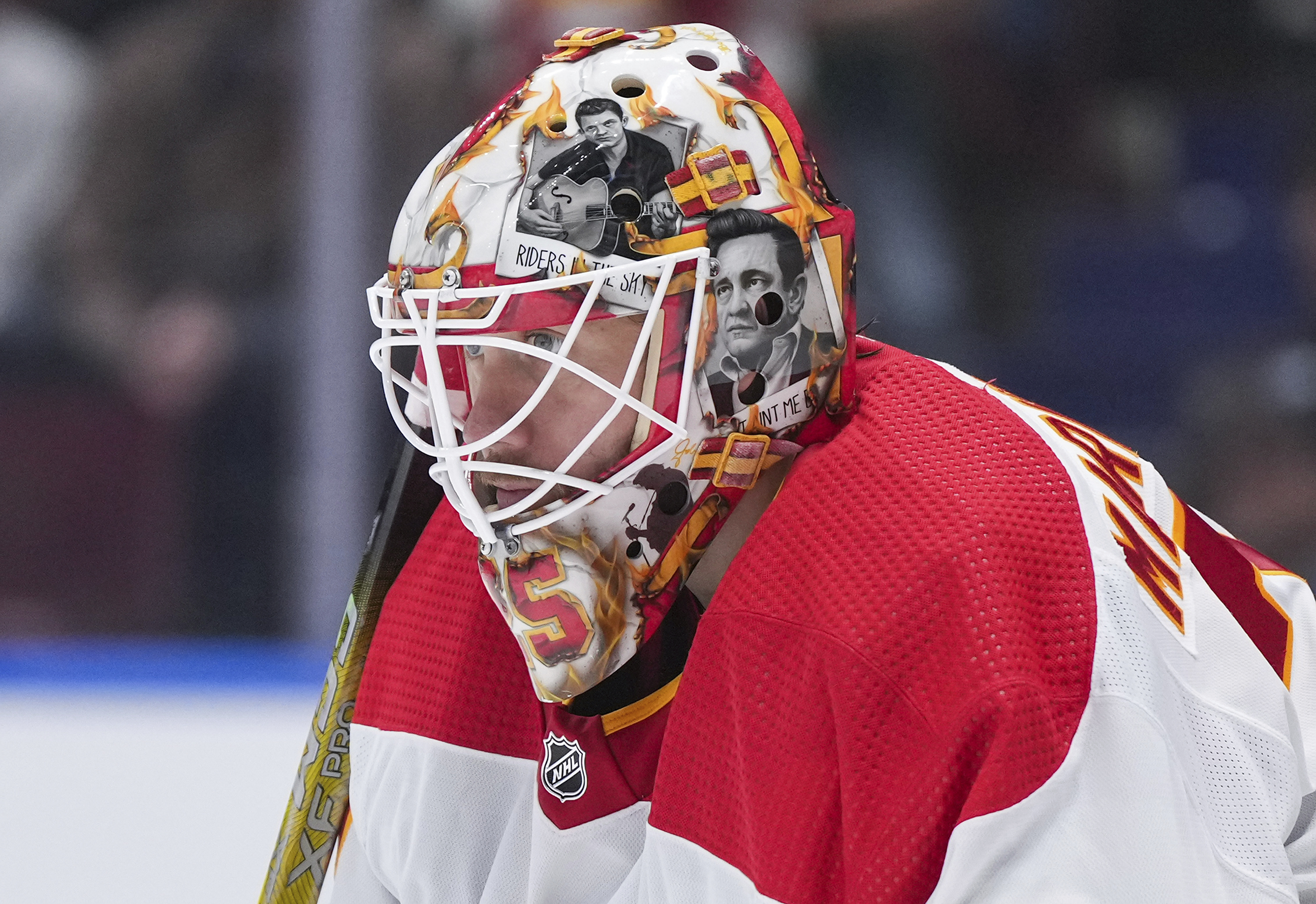 FILE - Artwork of Johnny Cash adorns the mask of Calgary Flames goalie Jacob Markstrom as he watches the action during the second period of an NHL hockey game against the Vancouver Canucks in Vancouver, British Columbia, March 23, 2024. The New Jersey Devils have agreed to acquire Markstrom in a trade with the Flames, a person with knowledge of the deal tells The Associated Press. It was not immediately clear what they were giving up. The Devils have been looking for a goalie and targeting Markstrom for quite some time. 