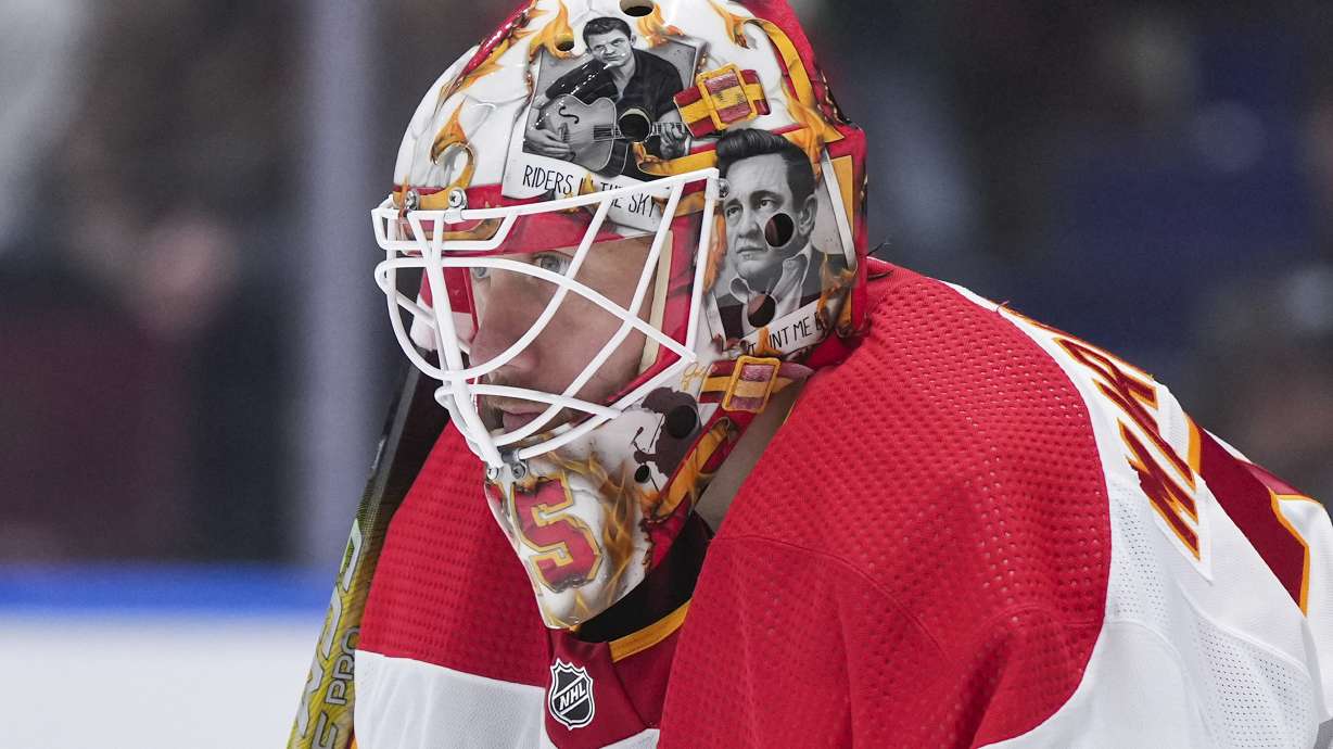 FILE - Artwork of Johnny Cash adorns the mask of Calgary Flames goalie Jacob Markstrom as he watches the action during the second period of an NHL hockey game against the Vancouver Canucks in Vancouver, British Columbia, March 23, 2024. The New Jersey Devils have agreed to acquire Markstrom in a trade with the Flames, a person with knowledge of the deal tells The Associated Press. It was not immediately clear what they were giving up. The Devils have been looking for a goalie and targeting Markstrom for quite some time.