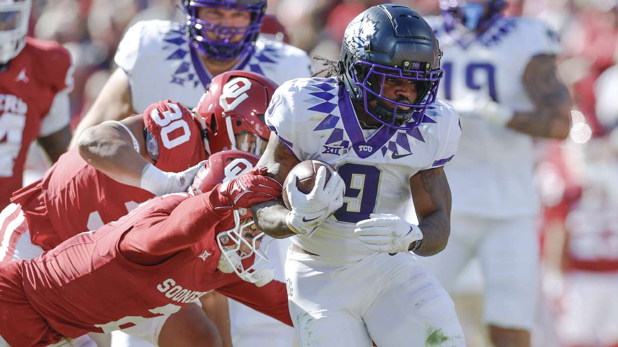 TCU running back Emani Bailey (9) is tackled by Oklahoma defensive back Billy Bowman Jr. (2) during the first half of an NCAA college football game Friday, Nov. 24, 2023, in Norman, Okla.