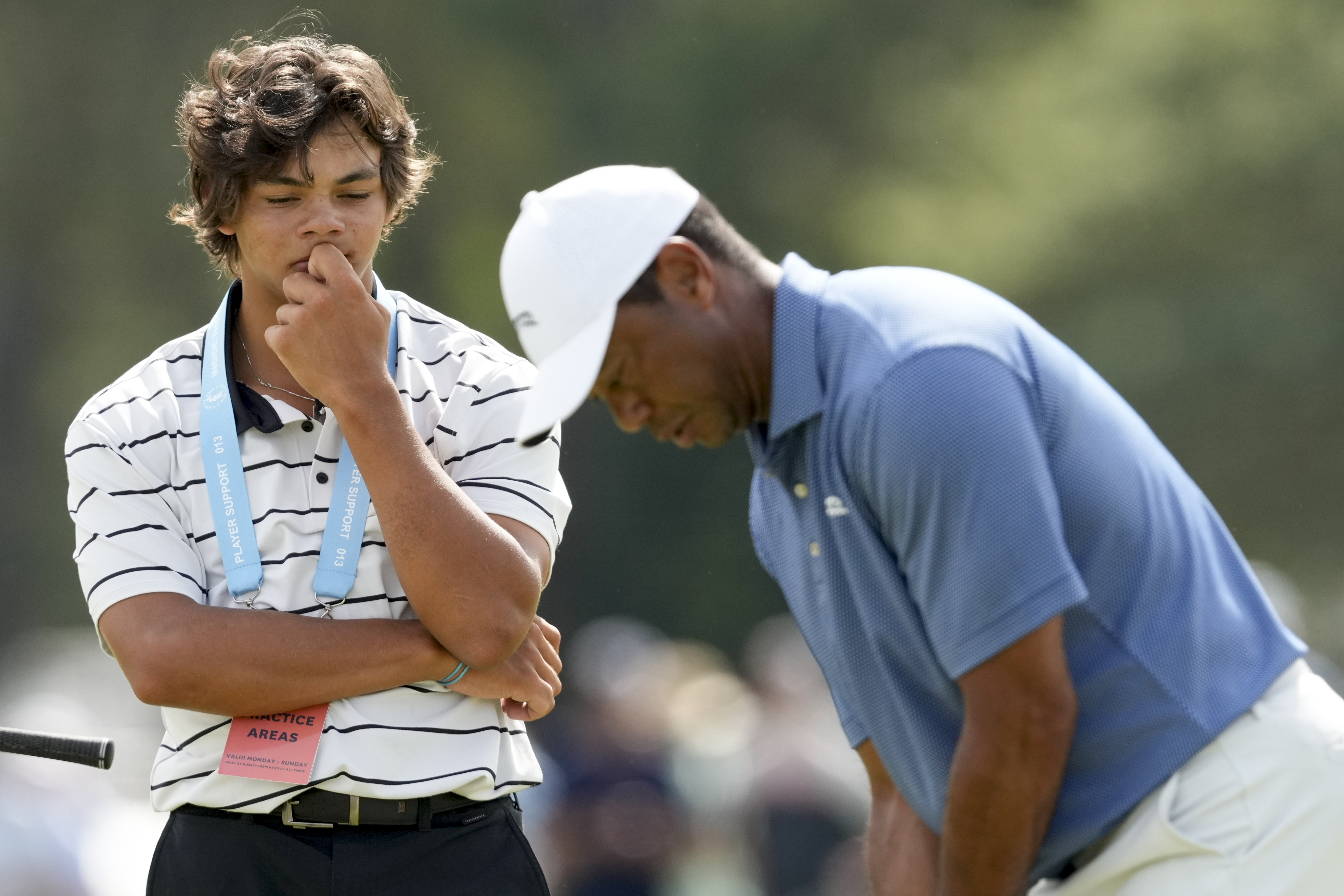Tiger Woods putts as his son, Charlie watches on the 18th hole during a practice round for the U.S. Open golf tournament Monday, June 10, 2024, in Pinehurst, N.C.