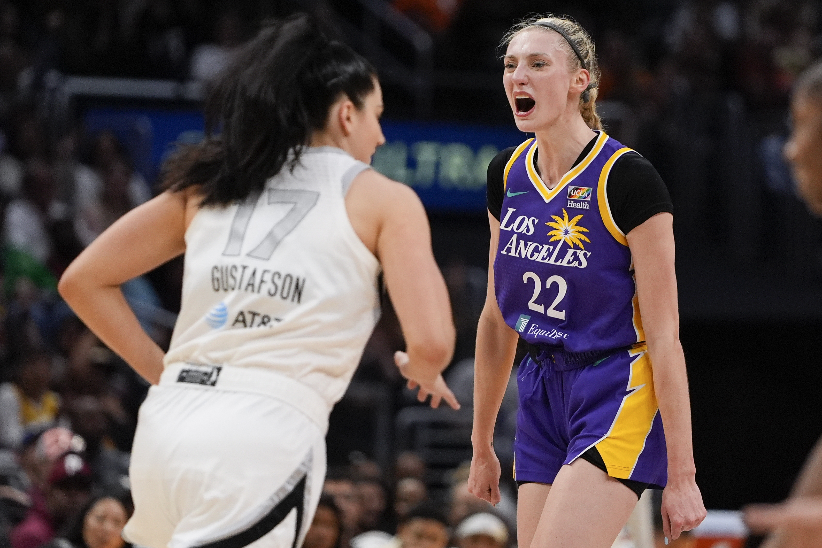 Los Angeles Sparks forward Cameron Brink (22) reacts near Las Vegas Aces center Megan Gustafson (17) after scoring a 3-point basket during the second half of a WNBA basketball game, Sunday, June 9, 2024, in Los Angeles. 