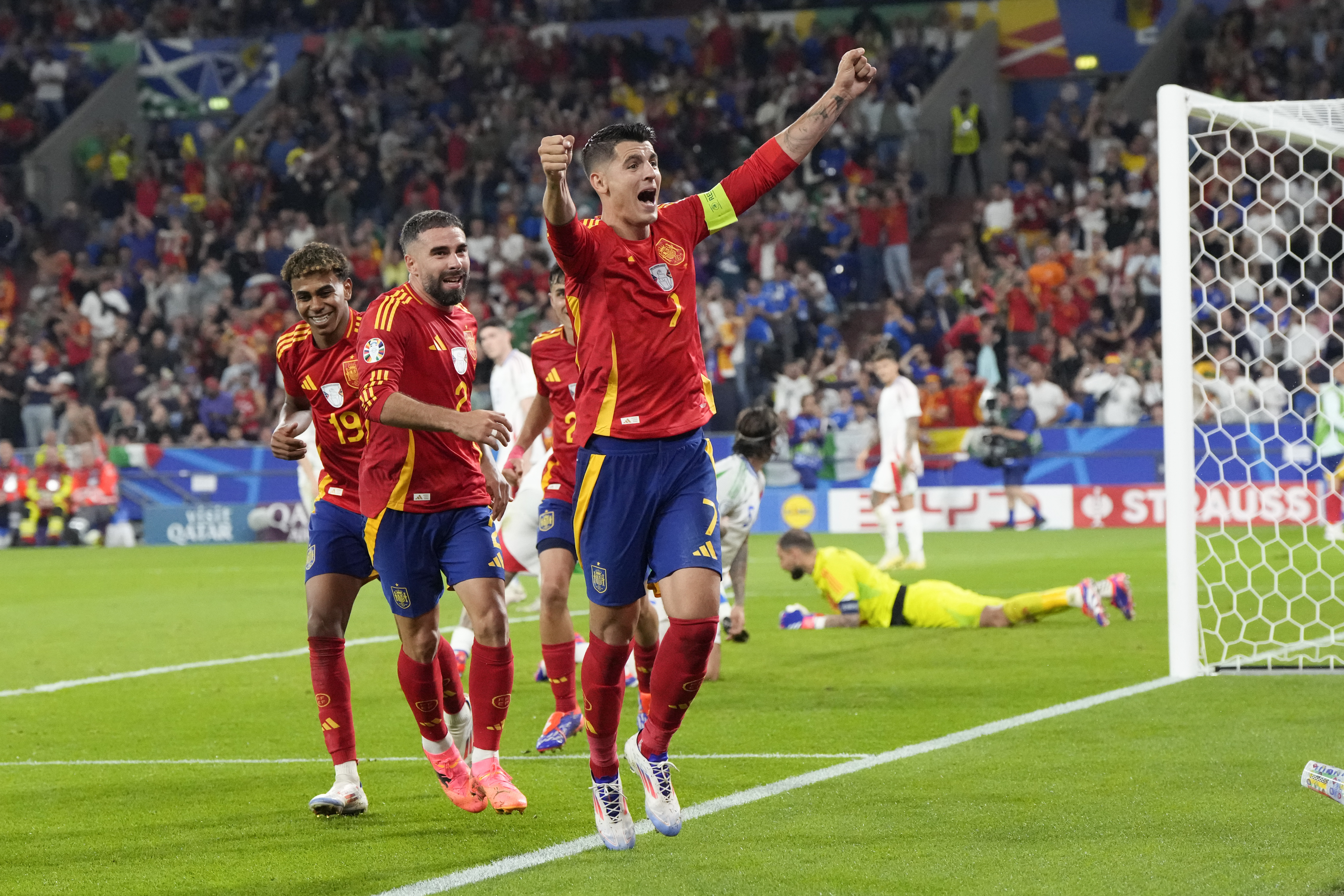Spain's Alvaro Morata (7) ) Dani Carvajal, center, and Lamine Yamal (19) celebrate after an own goal by Italy's Riccardo Calafiori during a Group B match between Spain and Italy at the Euro 2024 soccer tournament in Gelsenkirchen, Germany, Thursday, June 20, 2024. 