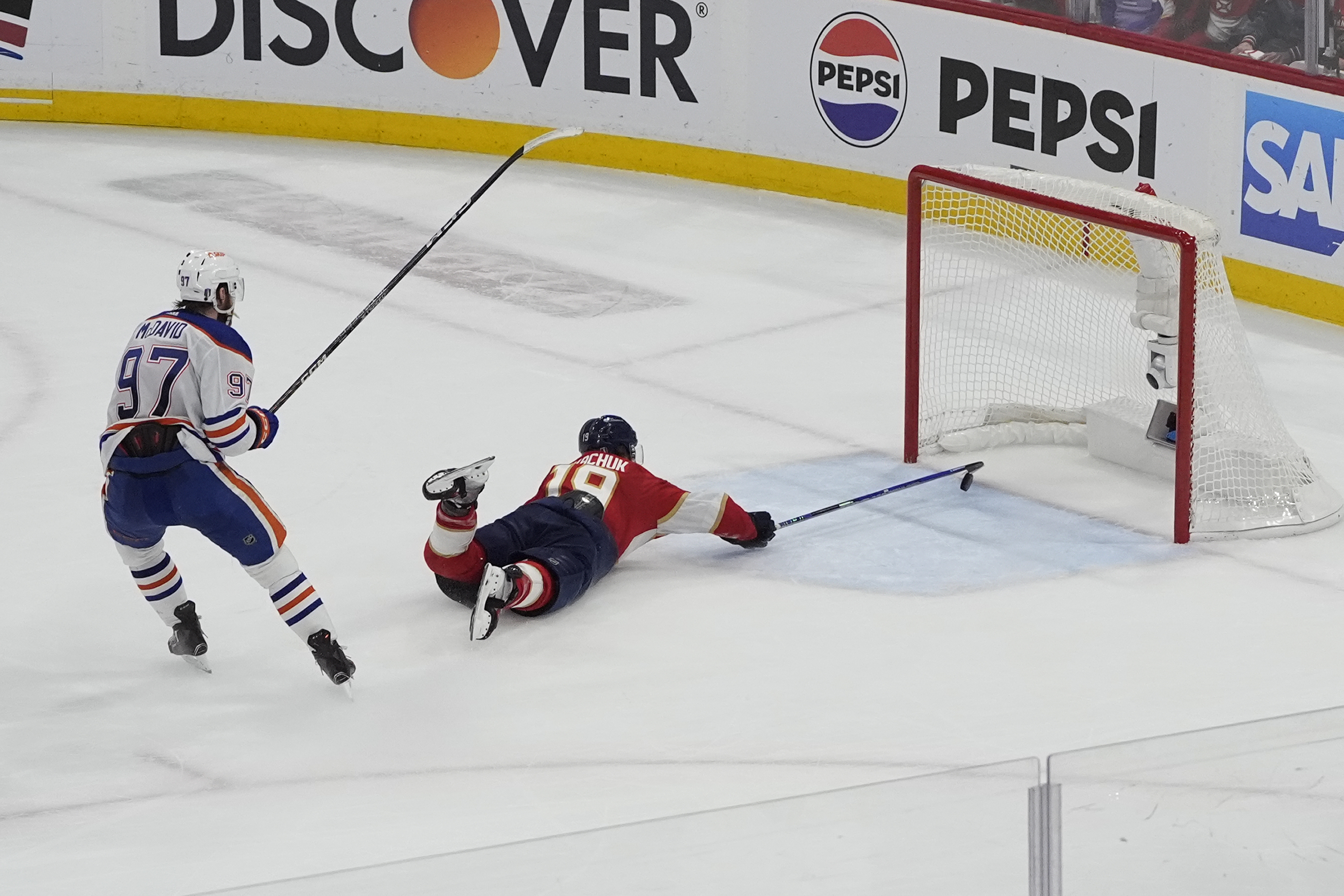 Florida Panthers left wing Matthew Tkachuk (19) attempts to stop a goal by Edmonton Oilers center Connor McDavid (97) during the third period of Game 5 of the NHL hockey Stanley Cup Finals, Tuesday, June 18, 2024, in Sunrise, Fla. The Oilers defeated the Panthers 5-3. 