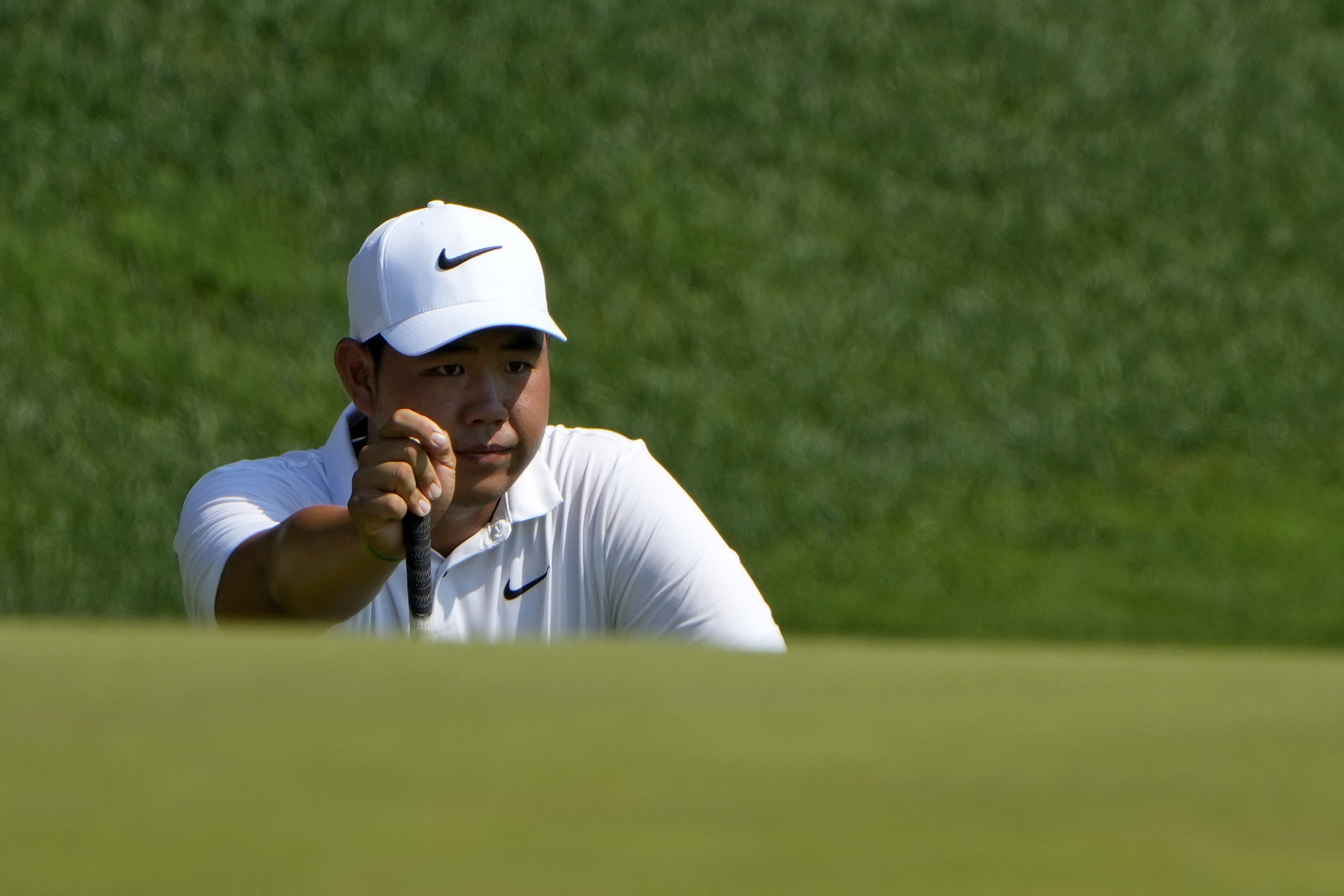 Tom Kim, of South Korea, lines up a shot on the 15th hole during the first round of the Travelers Championship golf tournament at TPC River Highlands, Thursday, June 20, 2024, in Cromwell, Conn.