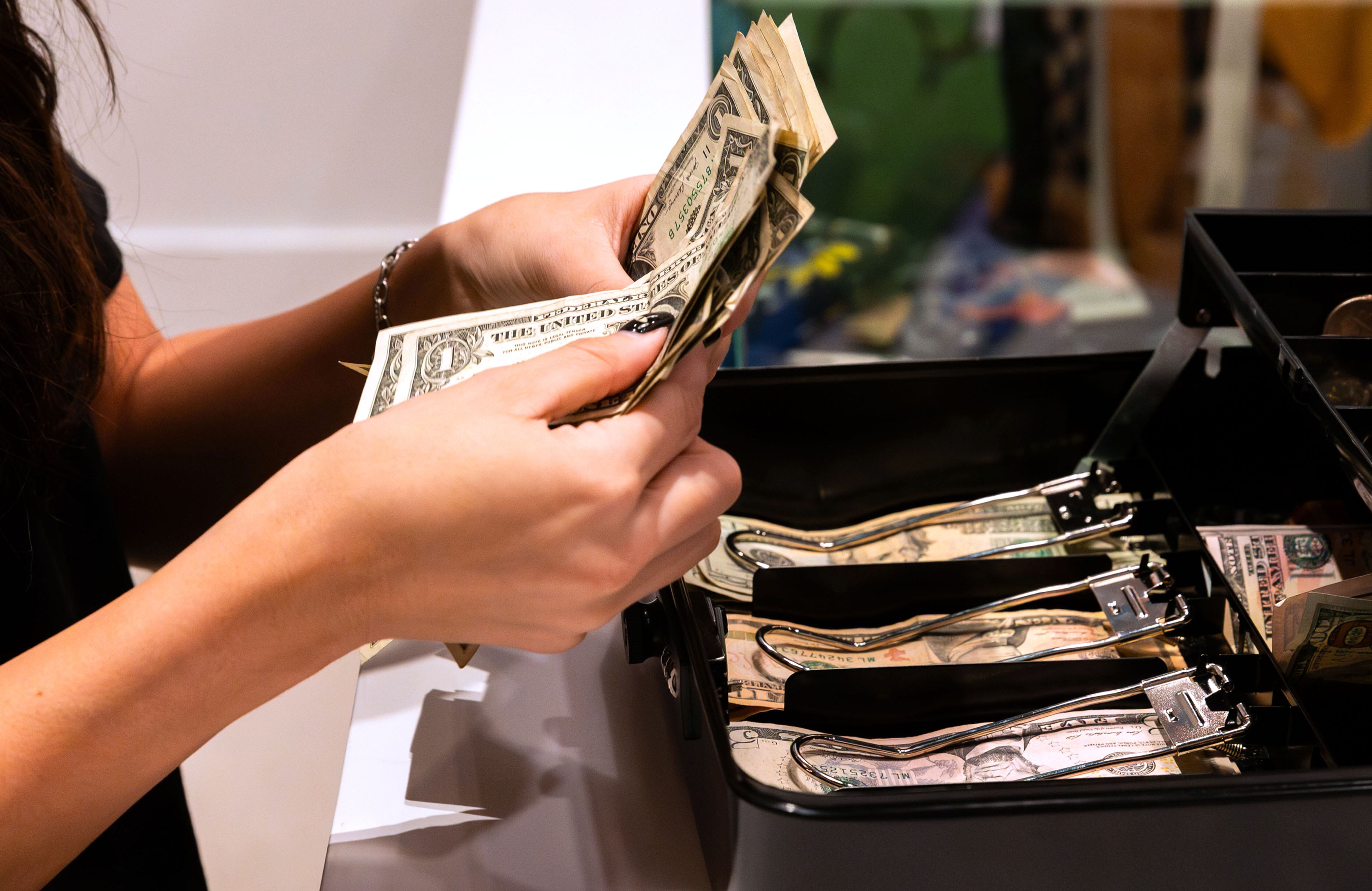 Brook Anderson counts cash from the cash box at City Creek Center in Salt Lake City on Nov. 24, 2023. Nearly half of Utah voters say financial issues — either price increases and inflation, or the economy and jobs — are the top issues impacting how they vote in the 2024 election.