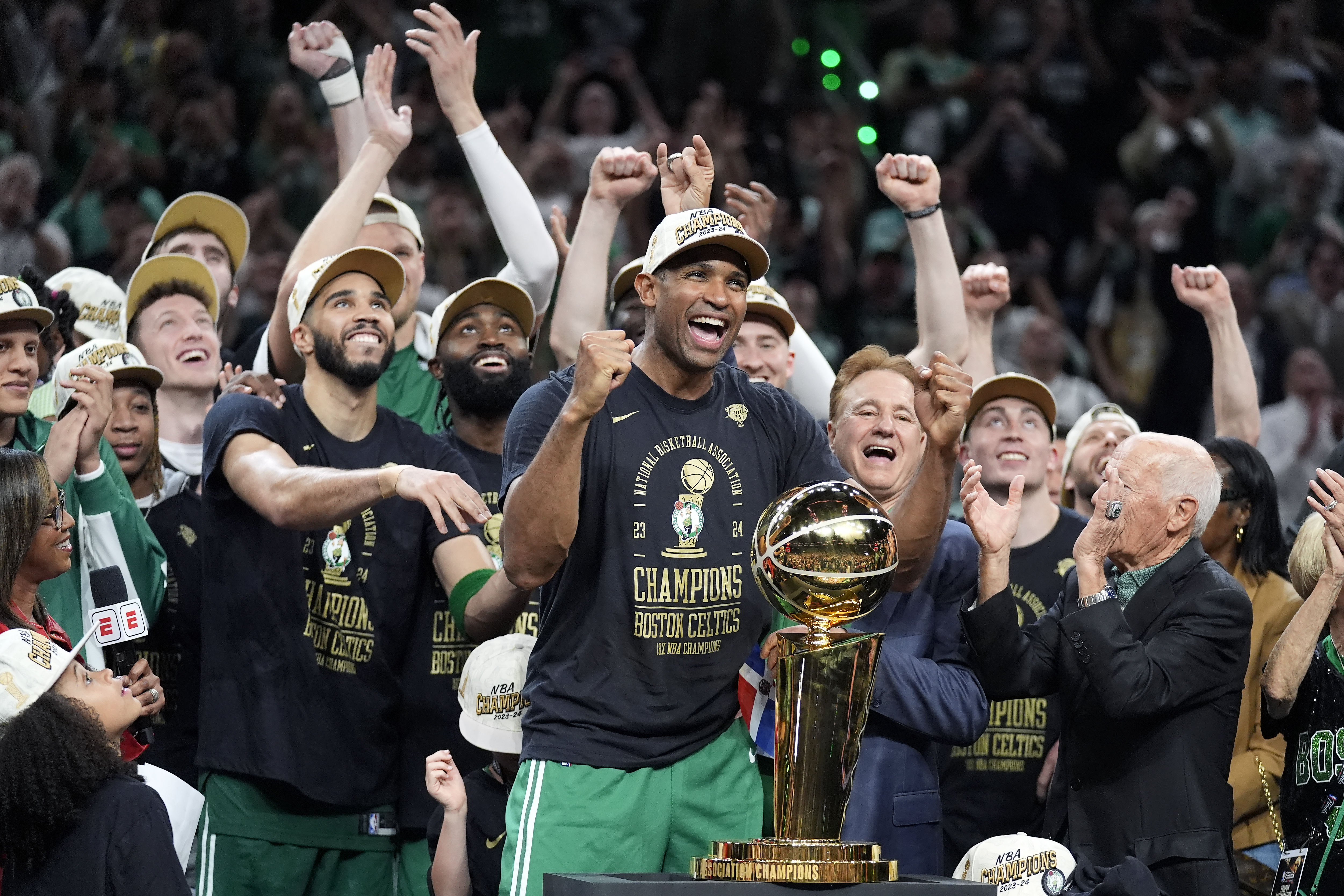 Boston Celtics center Al Horford, center, and forward Jayson Tatum, front center left, celebrate with teammates near the Larry O'Brien Championship Trophy after winning the NBA championship with a Game 5 victory over the Dallas Mavericks on Monday, June 17, 2024, in Boston. 