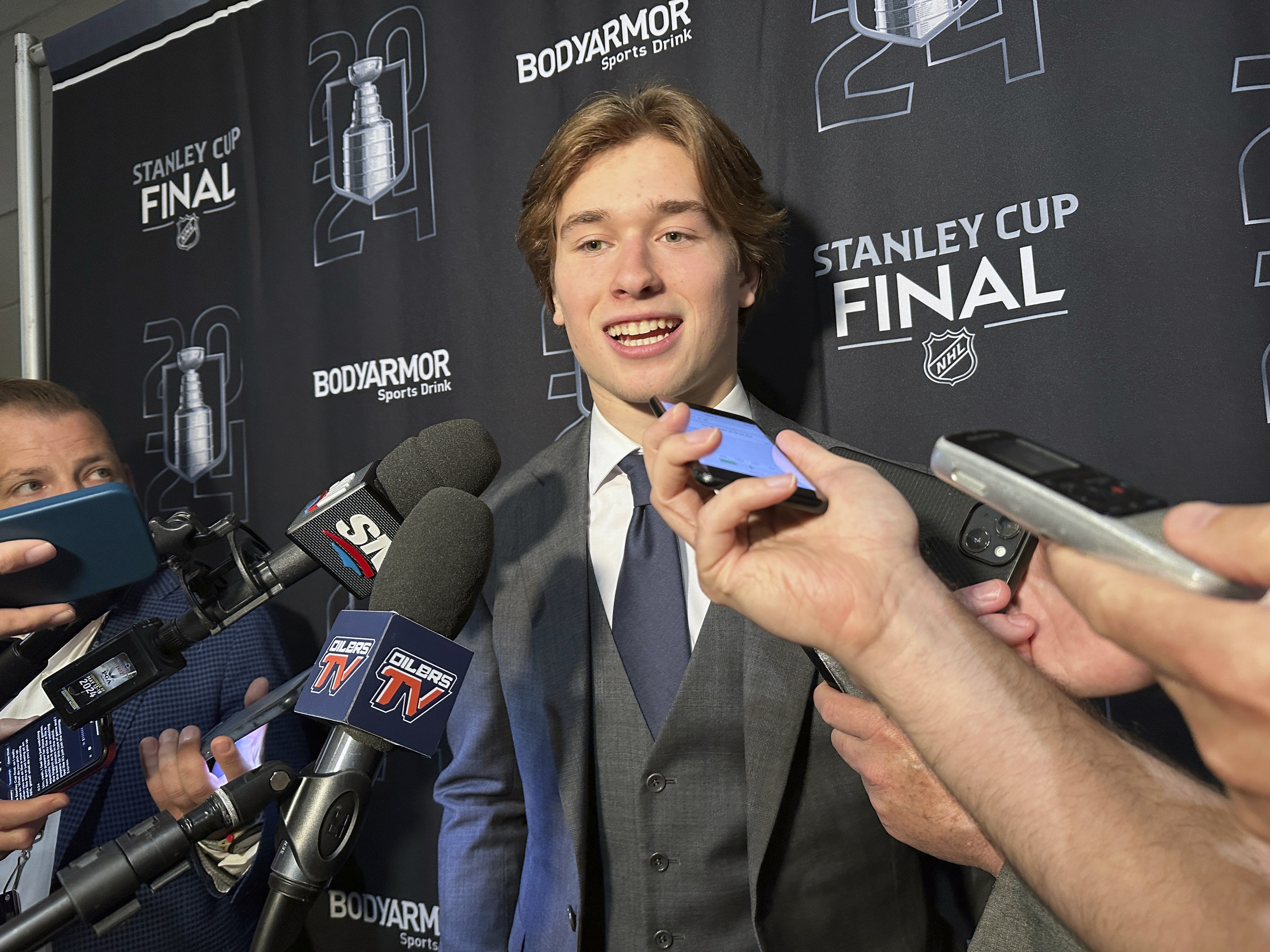 FILE - Macklin Celebrini, the expected No. 1 pick in the NHL draft to the San Jose Sharks, speaks with reporters prior to Game 2 of the Stanley Cup Final at Amerant Bank Arena in Sunrise, Florida, Monday, June 10, 2024. Celebrini sets aside his NBA ties by looking ahead to a hockey career, entering the NHL draft as the presumptive No. 1 pick on Friday, June 28. 