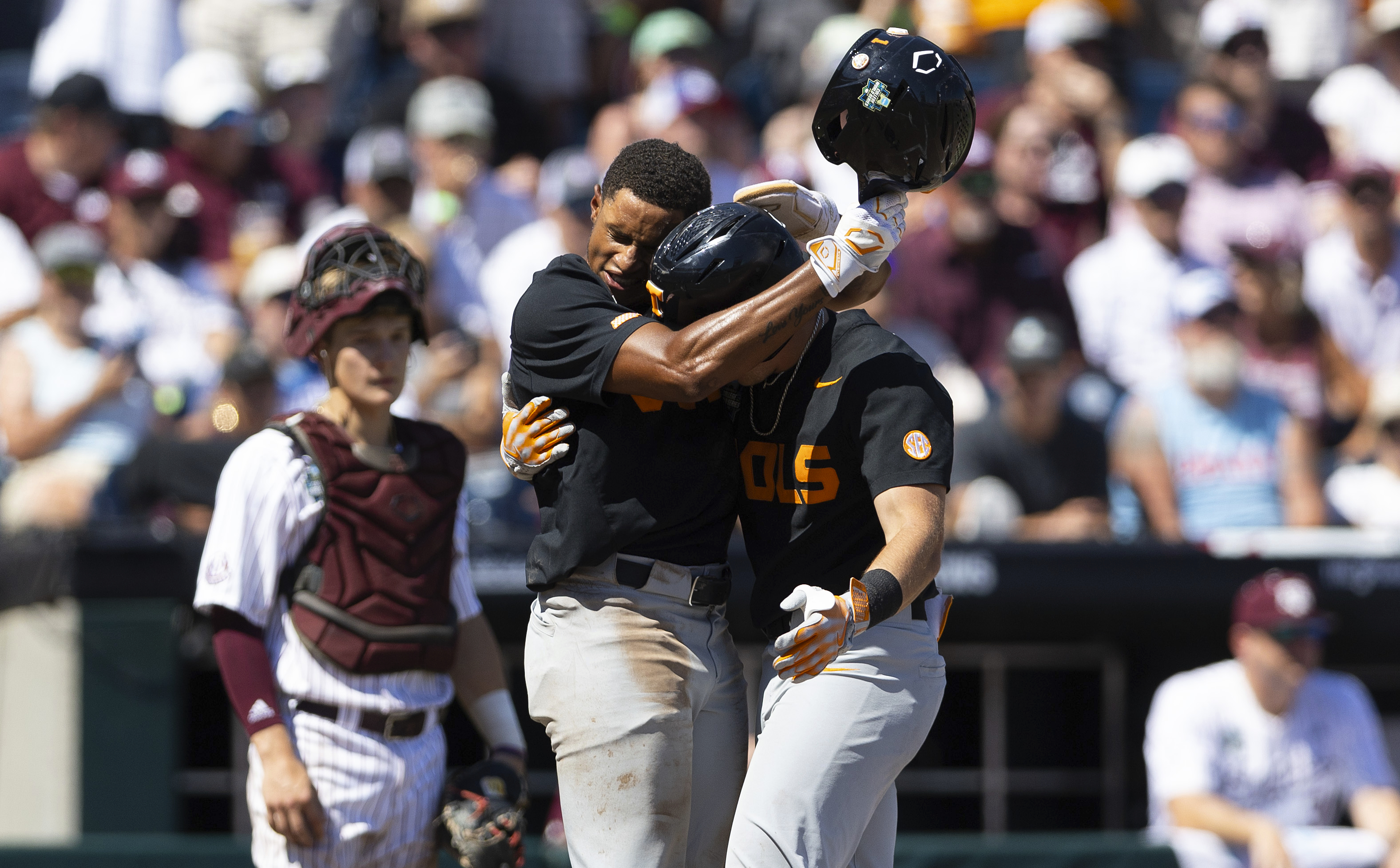 Tennessee's Christian Moore, left, hugs Dylan Dreiling at home plate after Dreiling hit a two-run home run against Texas A&M in the seventh inning of Game 2 of the NCAA College World Series baseball finals in Omaha, Neb., Sunday, June 23, 2024. 