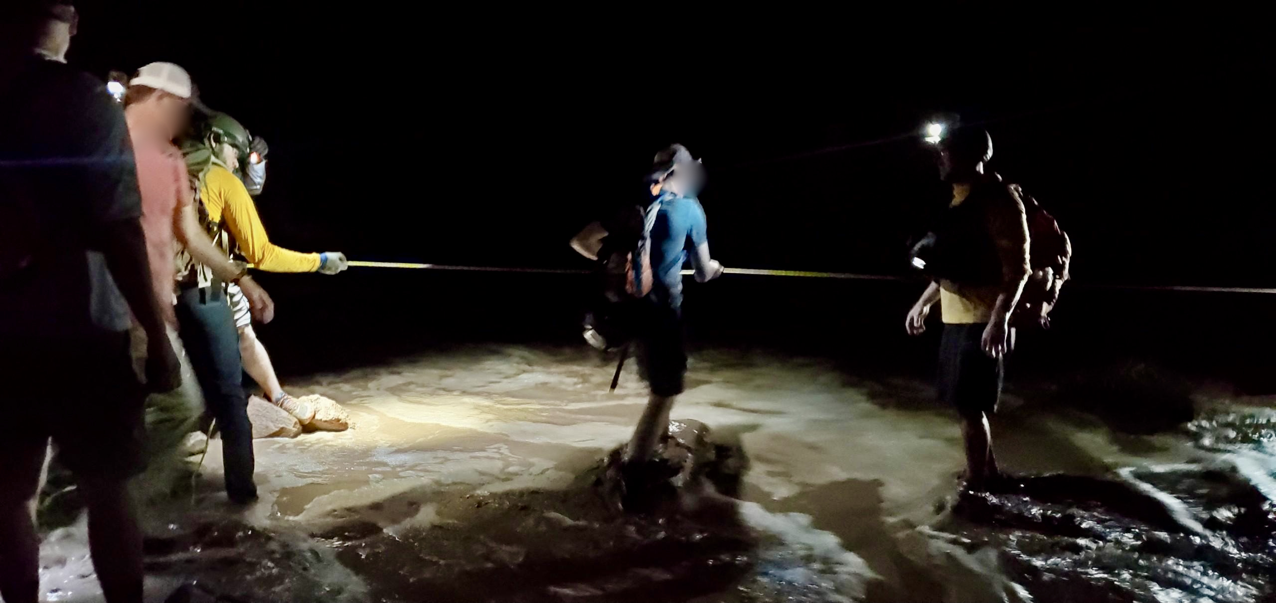 Grand County sheriff's search-and-rescue teams help hikers cross a flooded creek in Grandstaff Canyon on Friday.