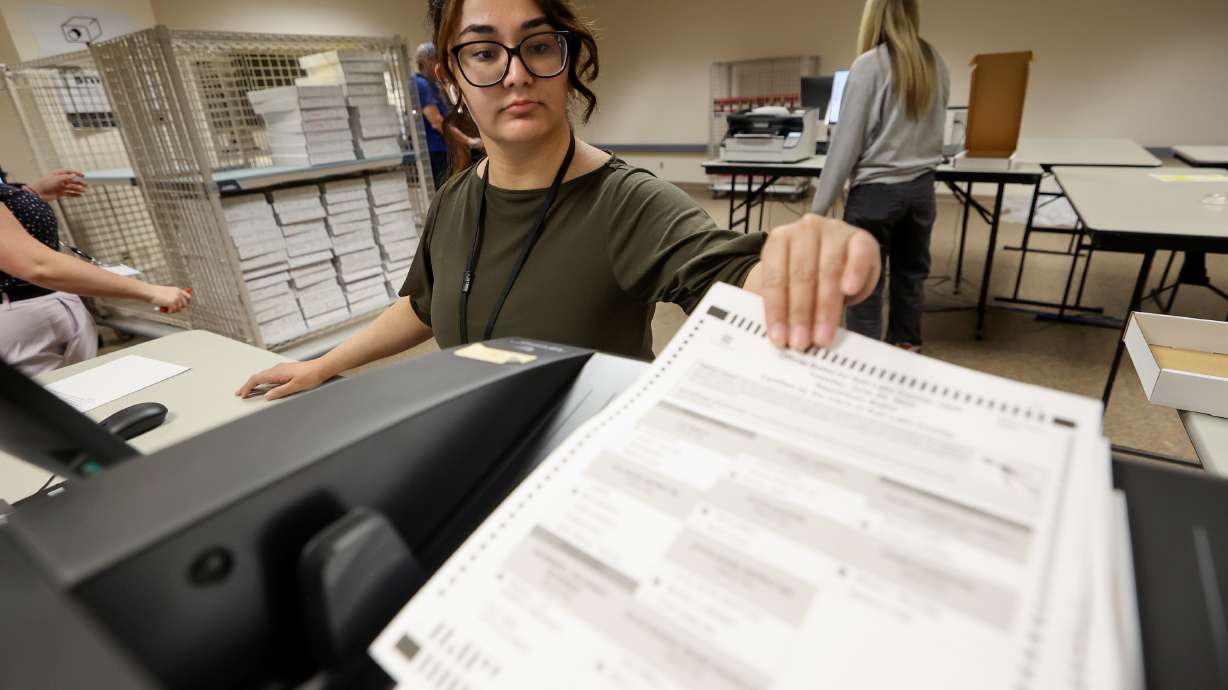 Latifa Yaqoobi, executive administrative assistant to Salt Lake County Clerk Lannie Chapman, scans ballots at the Salt Lake County Government Center in Salt Lake City on Wednesday.