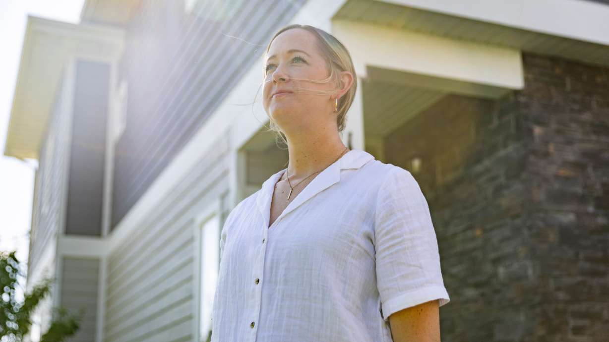 Erin Woodlief Ellis poses for a portrait outside her home in Bluffdale on Tuesday. As a single buyer, the homebuying process can be daunting, and the choice to buy or to stay renting is largely a financial one.