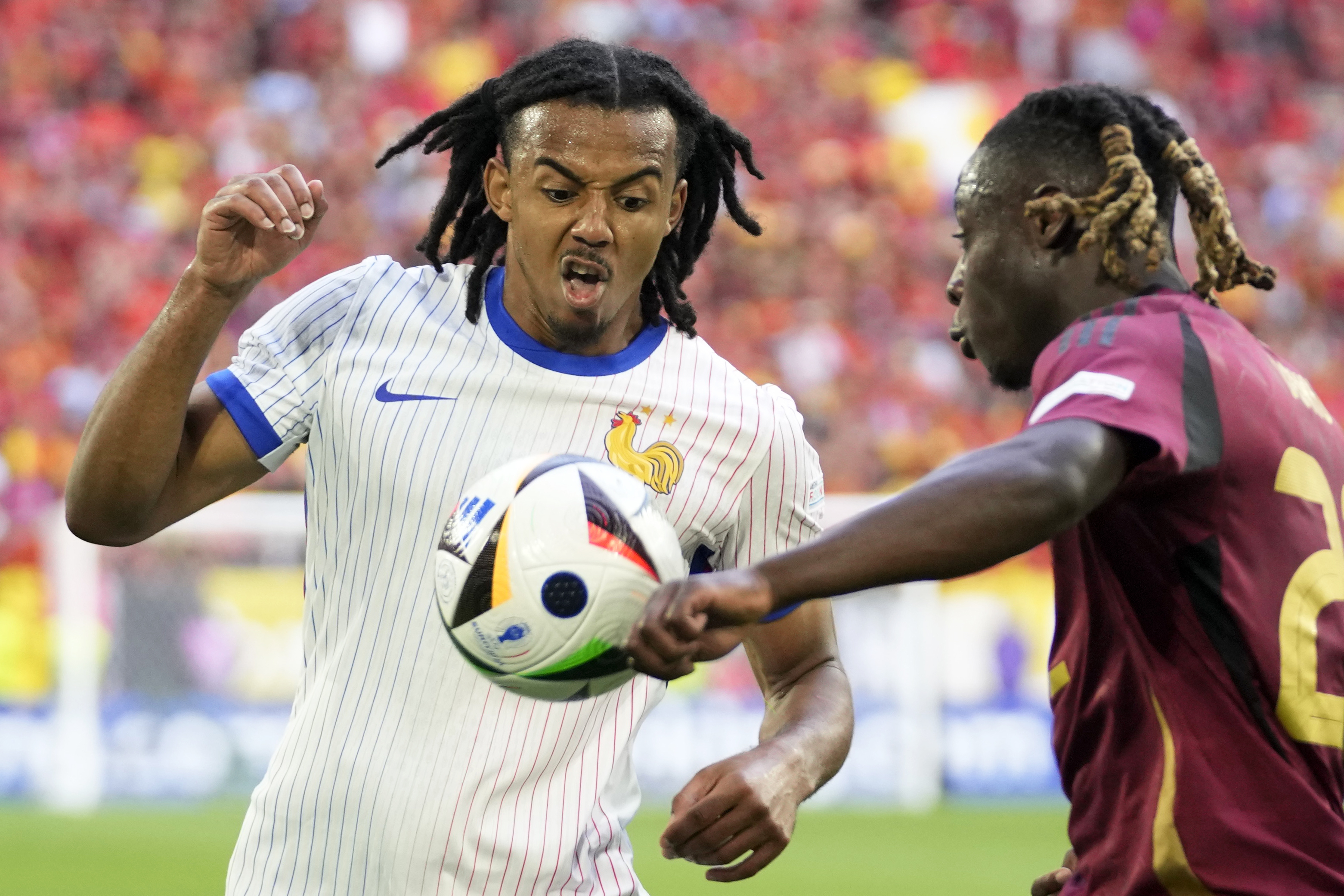 Jules Kounde of France, left, vies for the ball with Belgium's Jeremy Doku during a round of sixteen match between France and Belgium at the Euro 2024 soccer tournament in Duesseldorf, Germany, Monday, July 1, 2024. 