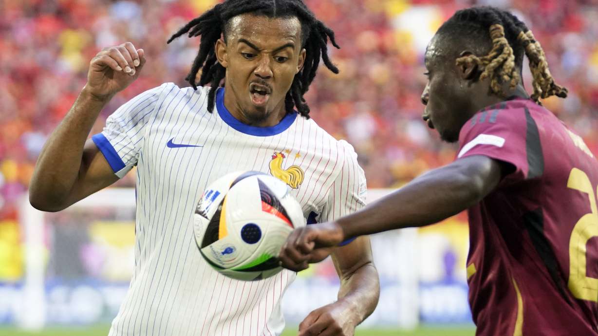 Jules Kounde of France, left, vies for the ball with Belgium's Jeremy Doku during a round of sixteen match between France and Belgium at the Euro 2024 soccer tournament in Duesseldorf, Germany, Monday, July 1, 2024.