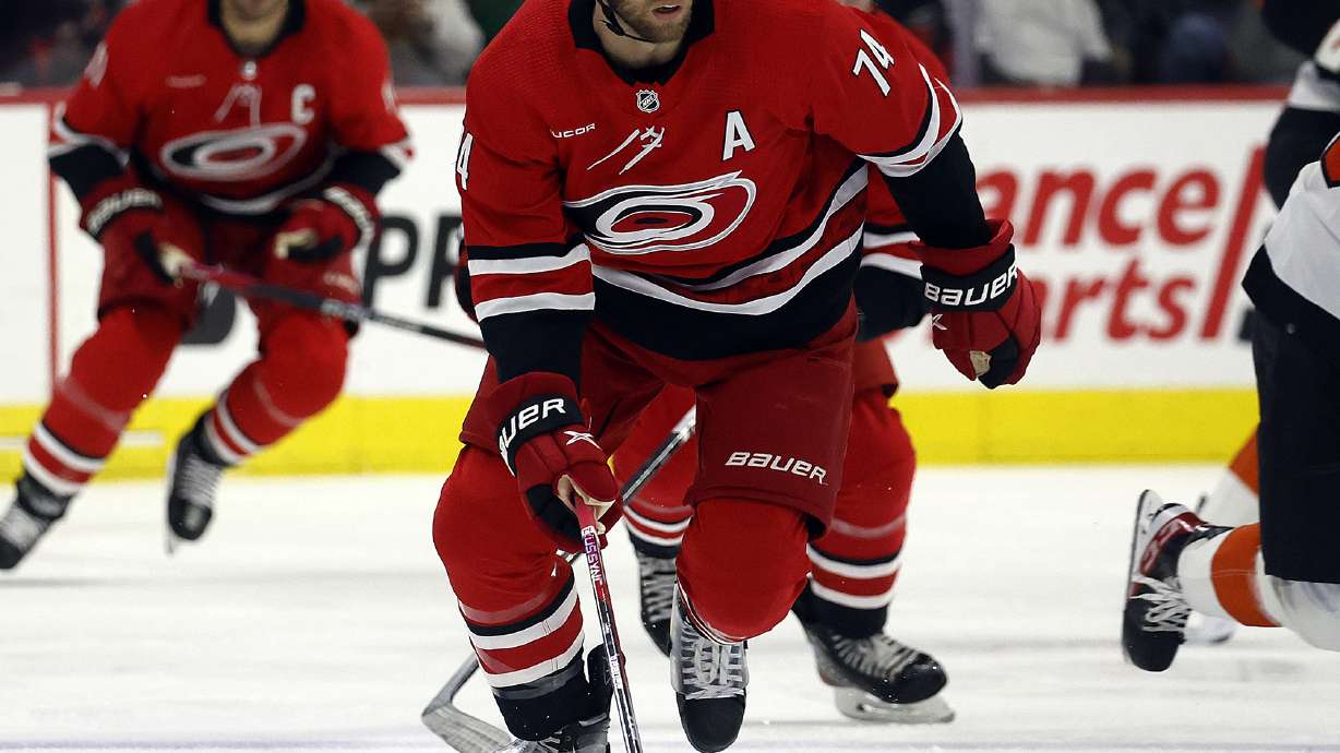 FILE - Carolina Hurricanes' Jaccob Slavin (74) chases the puck against the Philadelphia Flyers during the first period of an NHL hockey game in Raleigh, N.C., March 21, 2024. Slavin has signed an eight-year, $51.69 million contract extension with the Hurricanes.