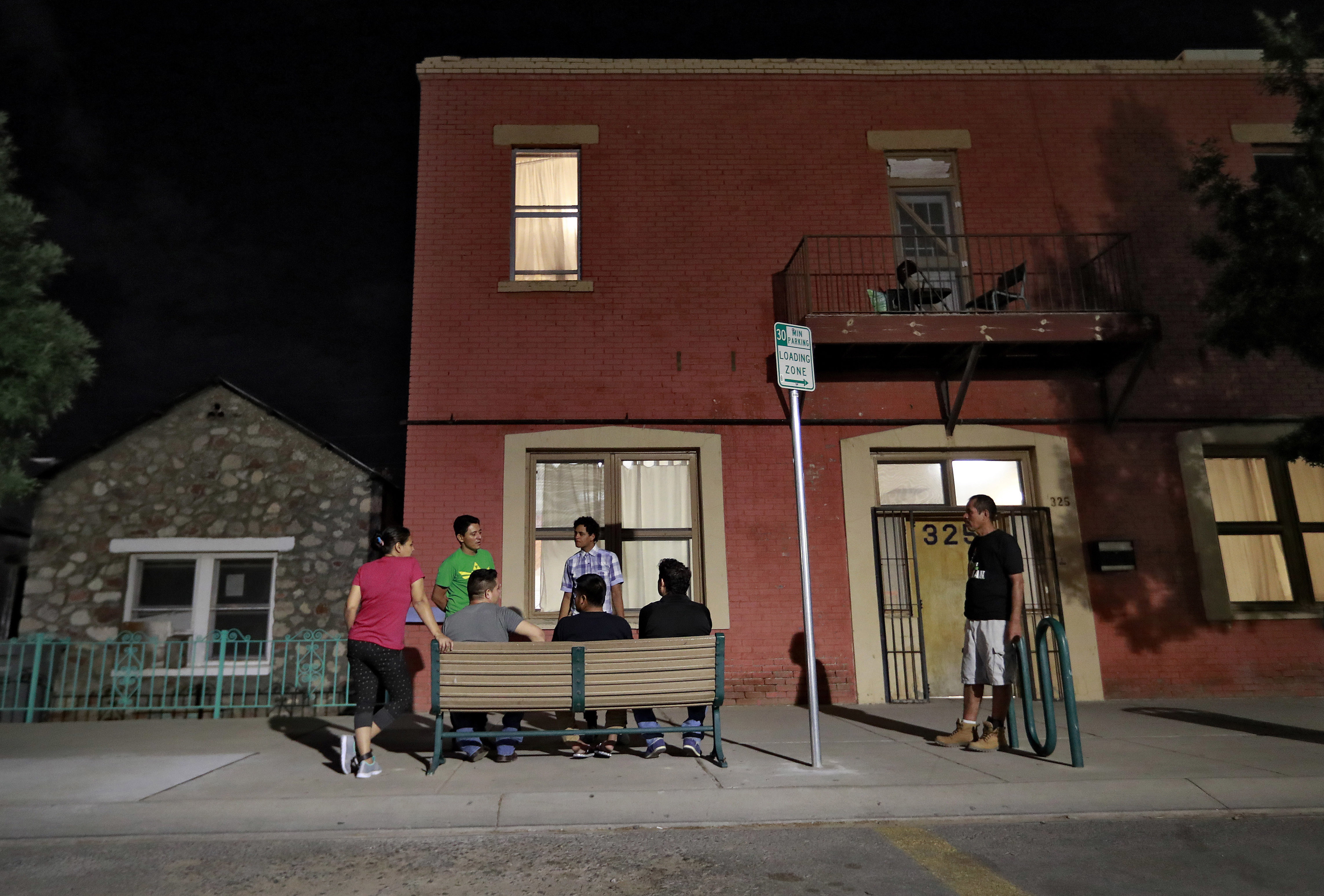 Migrant parents socialize outside the Annunciation House, June 26, 2018, in El Paso, Texas. A Texas judge ruled Tuesday against efforts to shut down a migrant shelter in El Paso that the Texas attorney general claimed encourages illegal migration. 