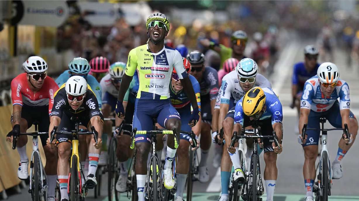 Biniam Girmay celebrates as he crosses the finish line ahead of Dylan Groenewegen, left, Arnaud de Lie, second left, Fernando Gavira, second right, and Fabio Jakobsen, right, to win the third stage of the Tour de France in Turin, Italy, Monday.