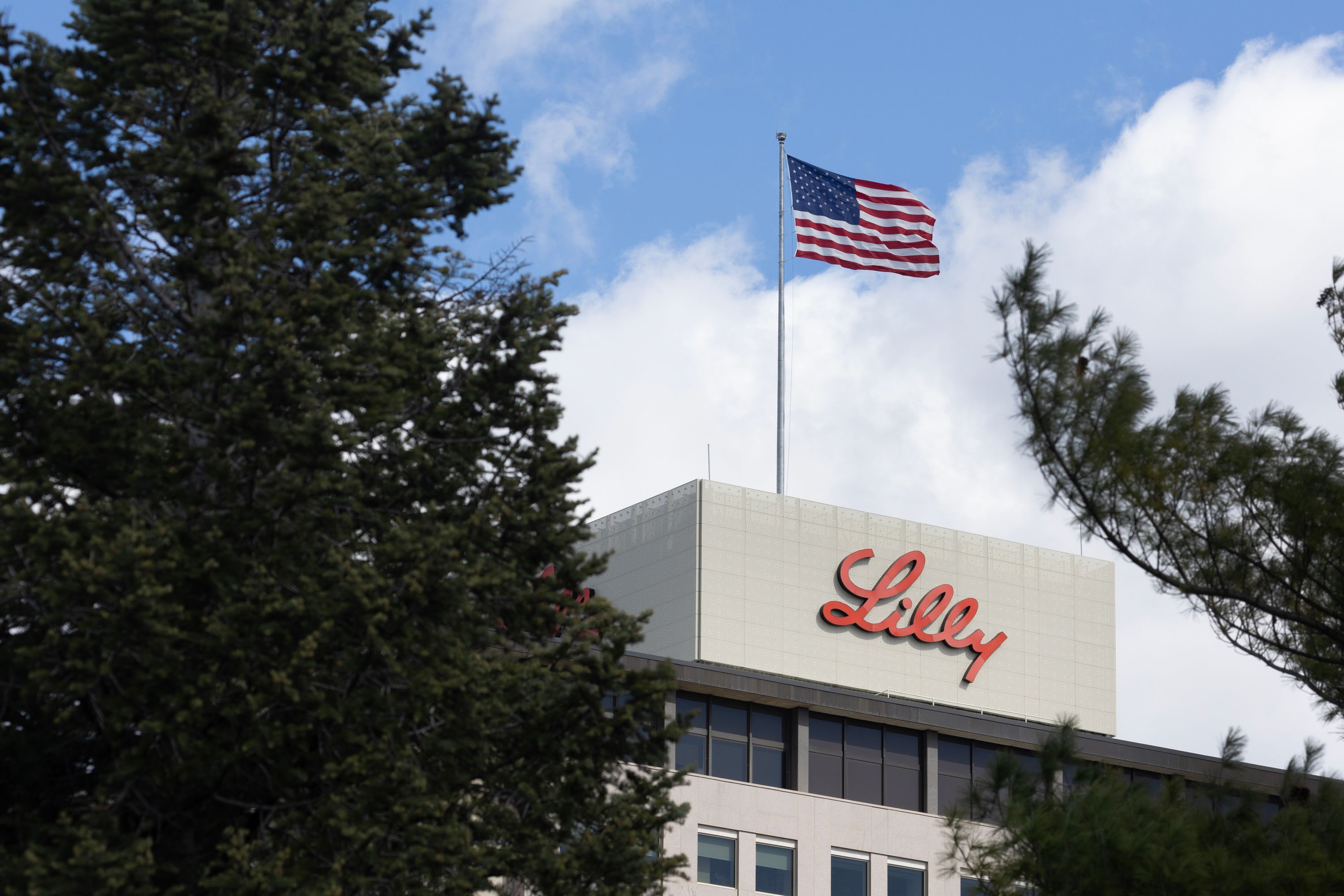 A flag flies above the headquarters campus of Eli Lilly and Company on March 17 in Indianapolis, Ind. The U.S. Food and Drug Administration on Tuesday approved donanemab-azbt, produced by Eli Lilly, which is a drug that slows cognitive and functional decline in people with early symptomatic Alzheimer’s disease.