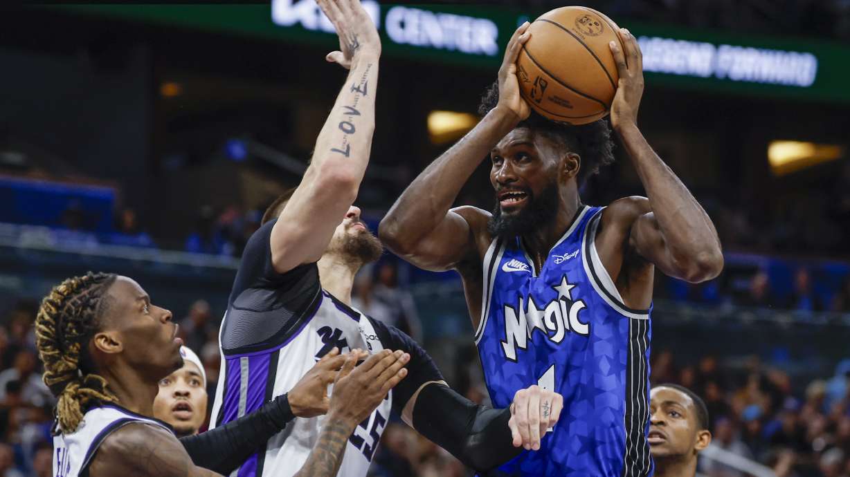 FILE -Orlando Magic forward Jonathan Isaac, right, goes to the basket as he is defended by Sacramento Kings center Alex Len, middle and Sacramento Kings guard Keon Ellis, left, during the second half of an NBA basketball game, Saturday, March 23, 2024, in Orlando, Fla. Jonathan Isaac has agreed to an $84 million deal that will keep him with Orlando for five more seasons, a person with knowledge of the negotiations said Tuesday, July 2, 2024.