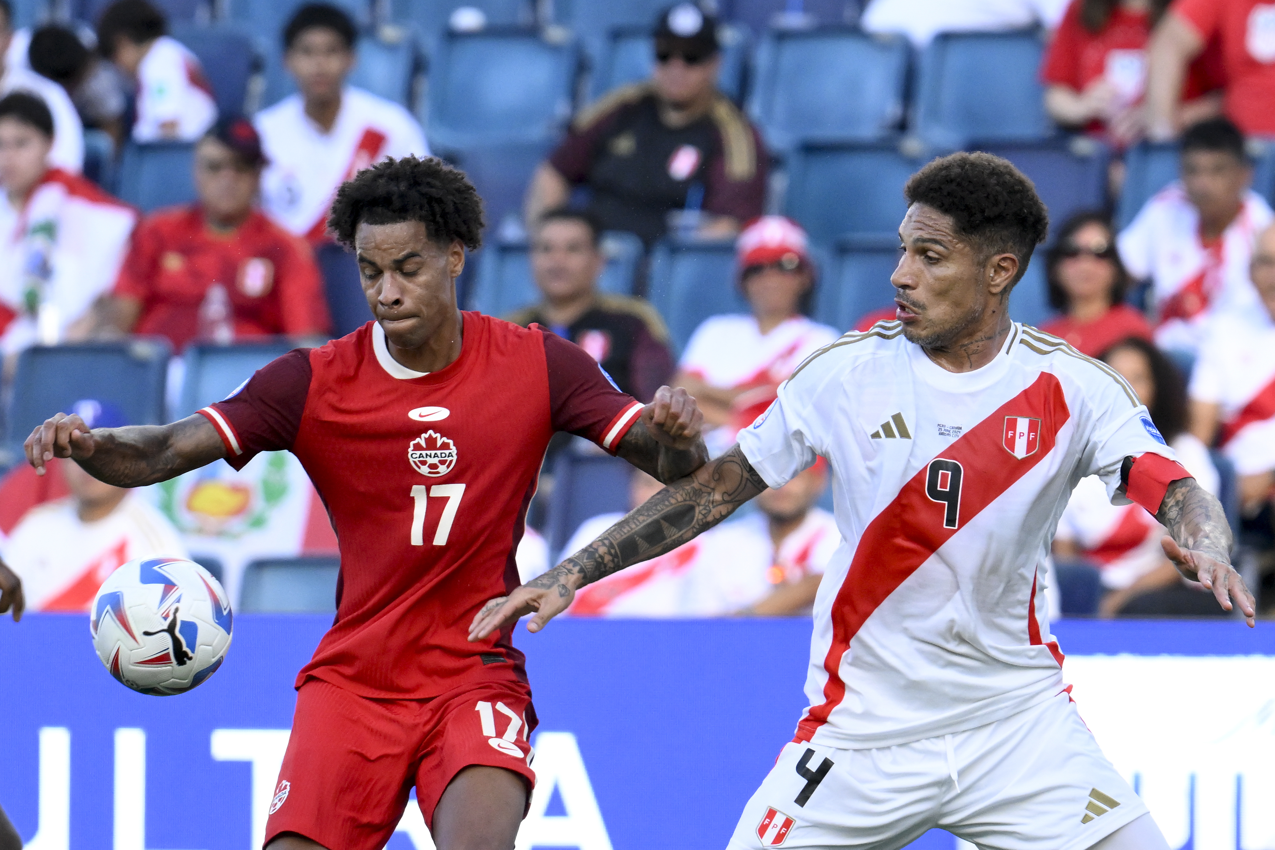 Canada's Tajon Buchanan, 17, and Peru's Paolo Guerrero battle for the ball during a Copa America Group A soccer match in Kansas City, Kan., Tuesday, June 25, 2024. 