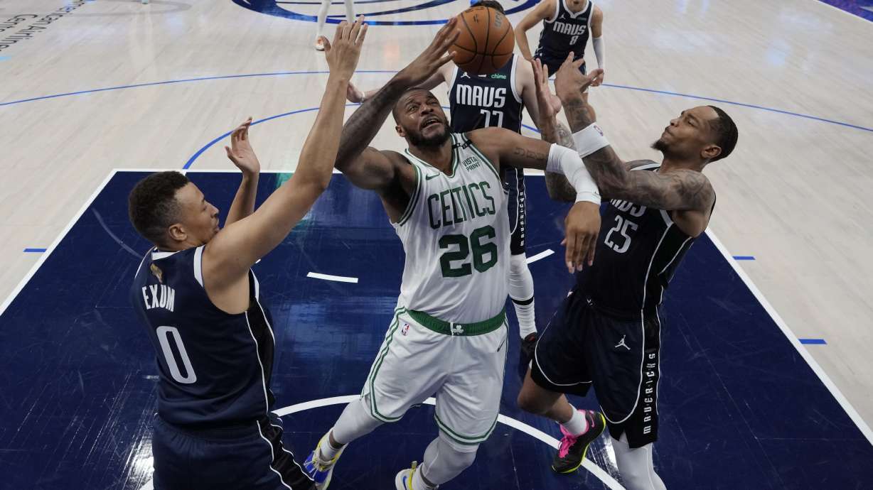Boston Celtics forward Xavier Tillman (26) battles Dallas Mavericks guard Dante Exum (0) and forward P.J. Washington (25) for a rebound during Game 4 of the NBA basketball finals, Friday, June 14, 2024, in Dallas.
